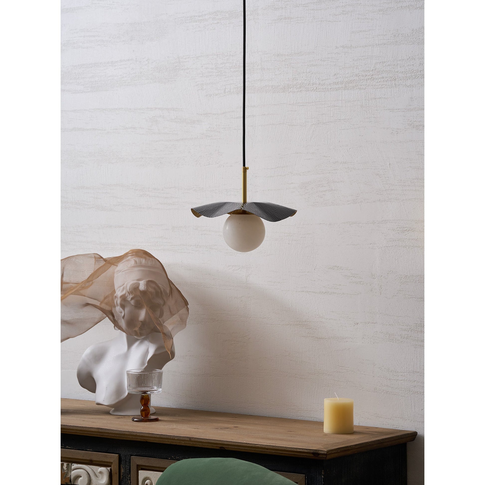 The pendant lamp used as a bedside light in a contemporary bedroom.