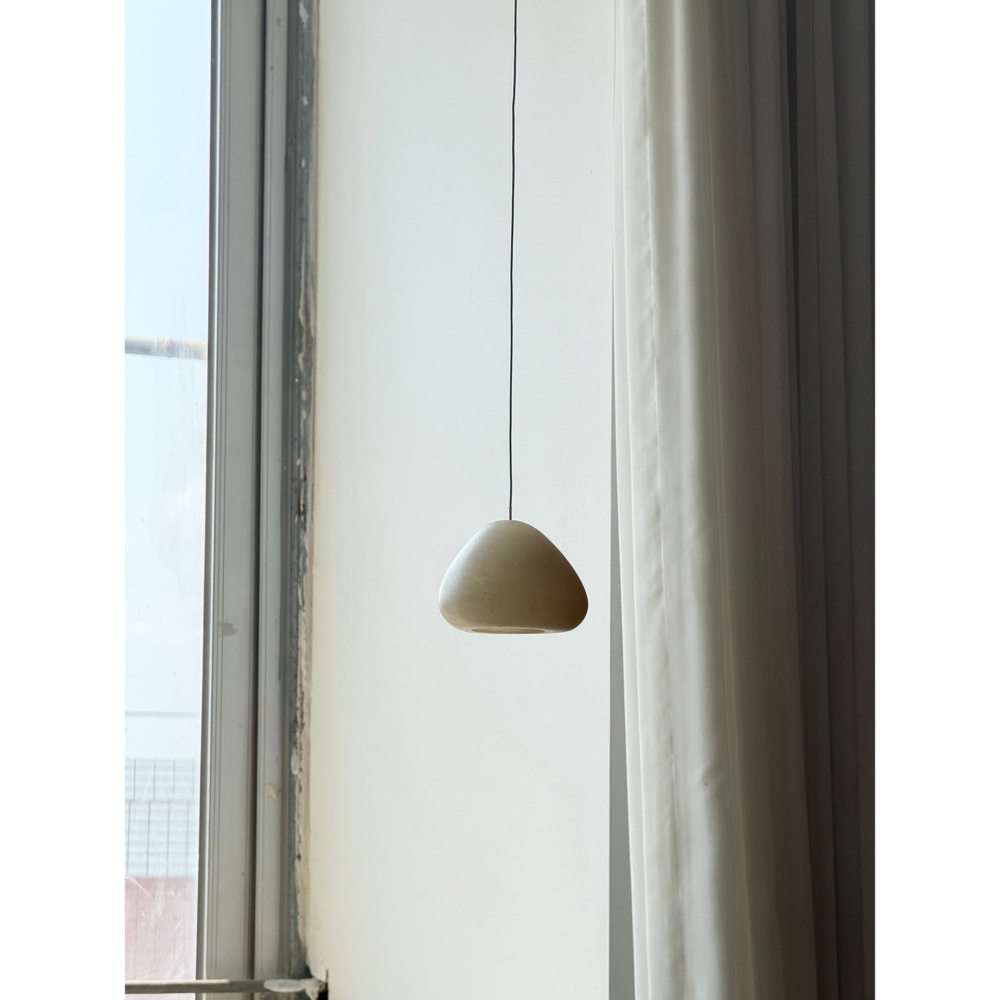 The lamp casting a soft, diffused light on a surface below.