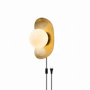 Nouvel Plug-in Wall Sconce in brass finish with frosted glass globe.