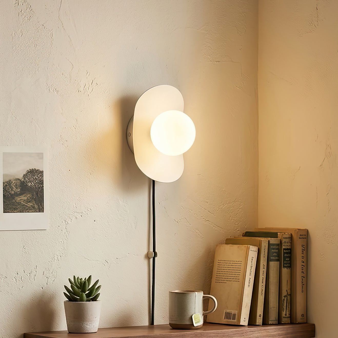 Close-up of the Nouvel Wall Sconce's brushed brass backplate and glass shade.