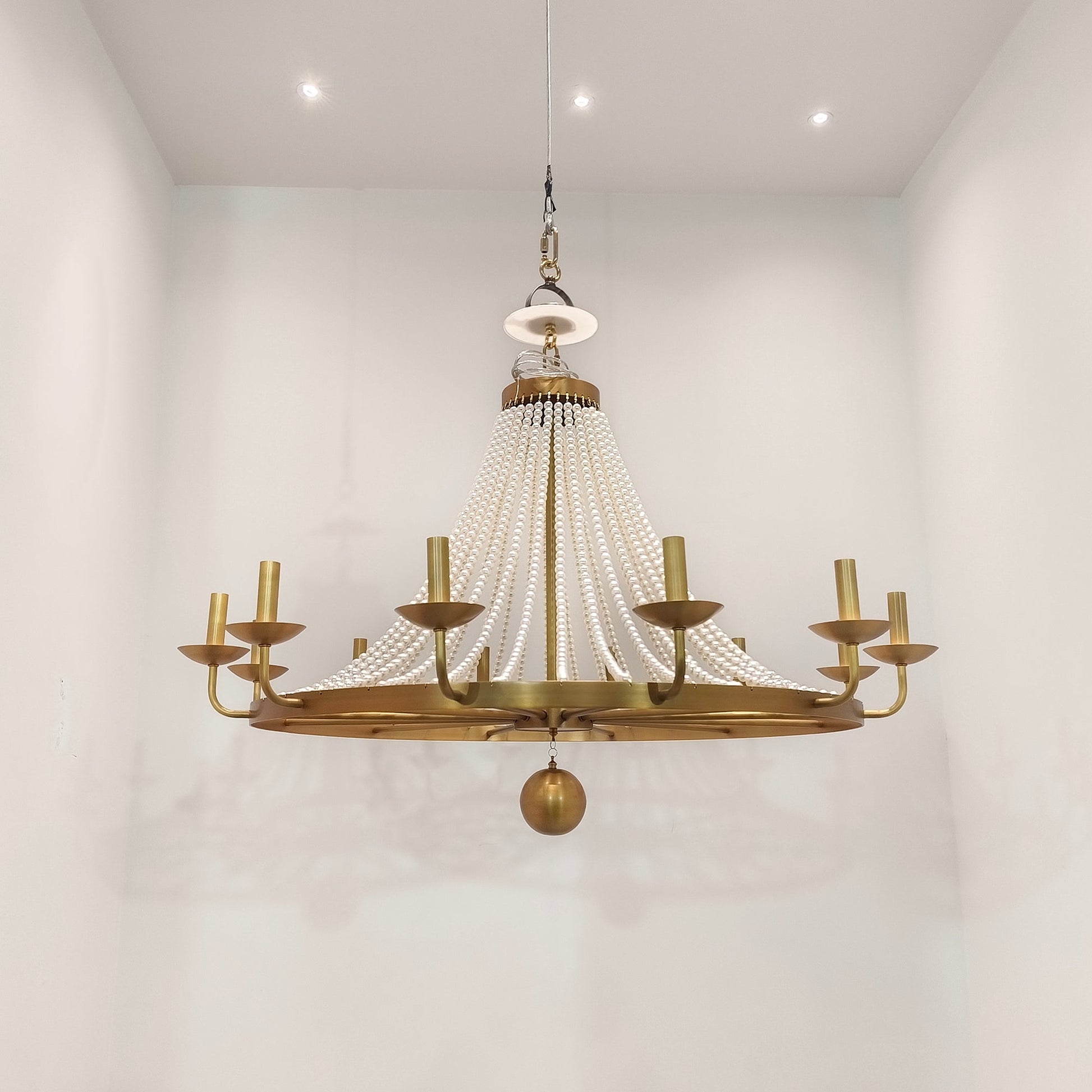 Product shot highlighting the contrast between the white pearls and brass finish.