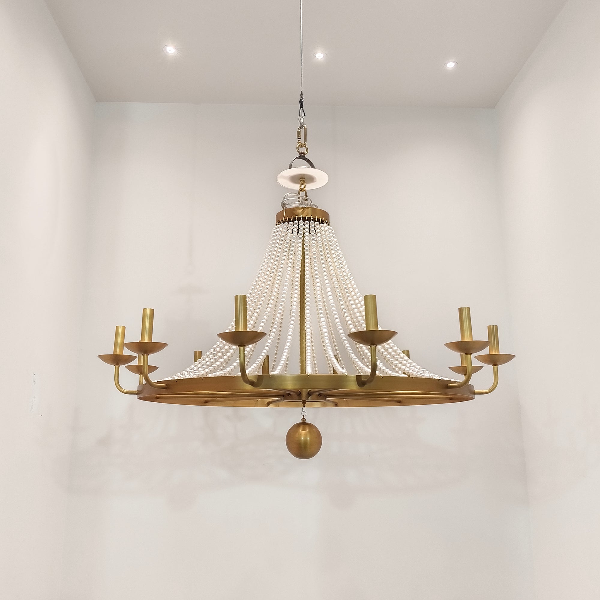 Product shot highlighting the contrast between the white pearls and brass finish.
