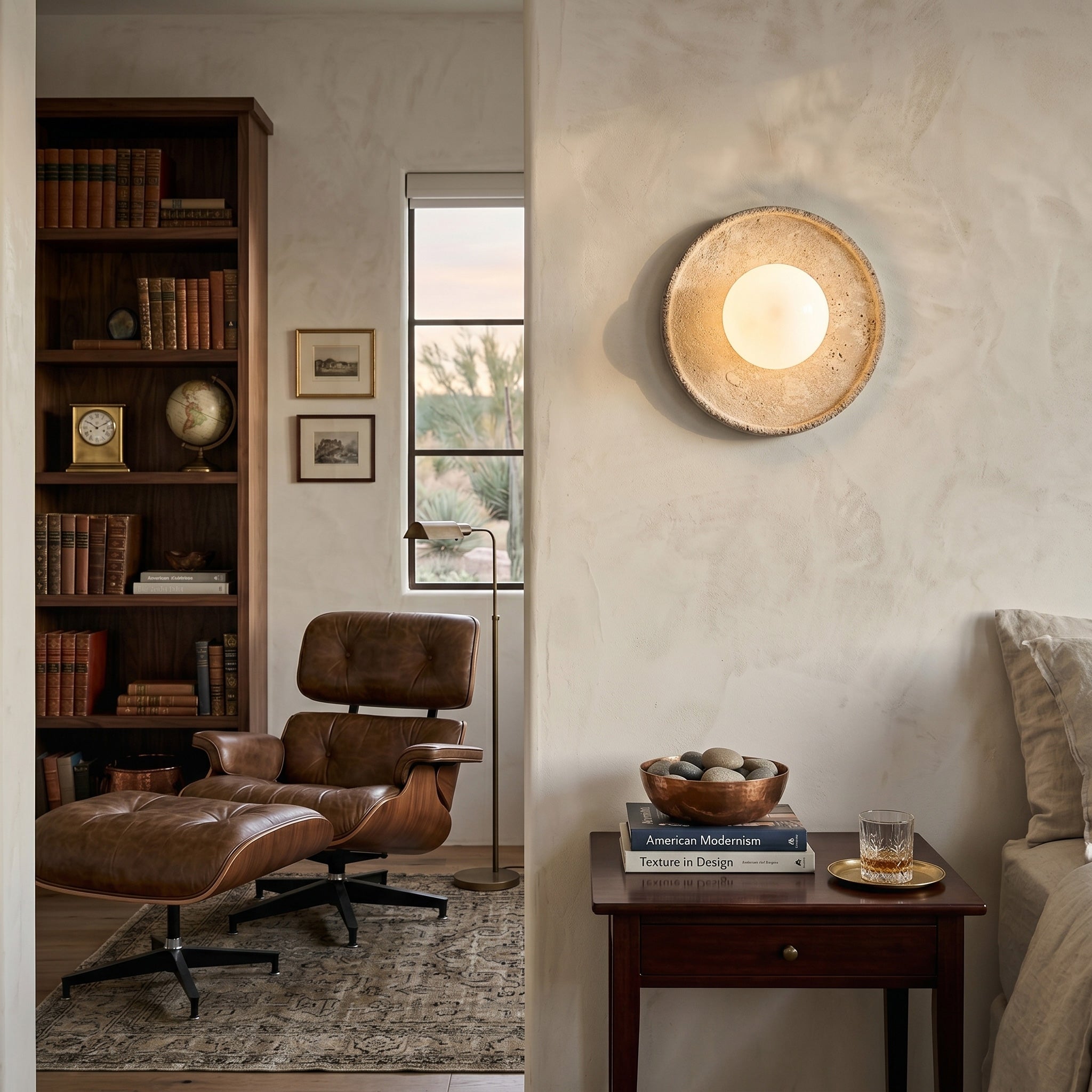 Riley Travertine Wall Sconce illuminated, casting a soft ambient glow.