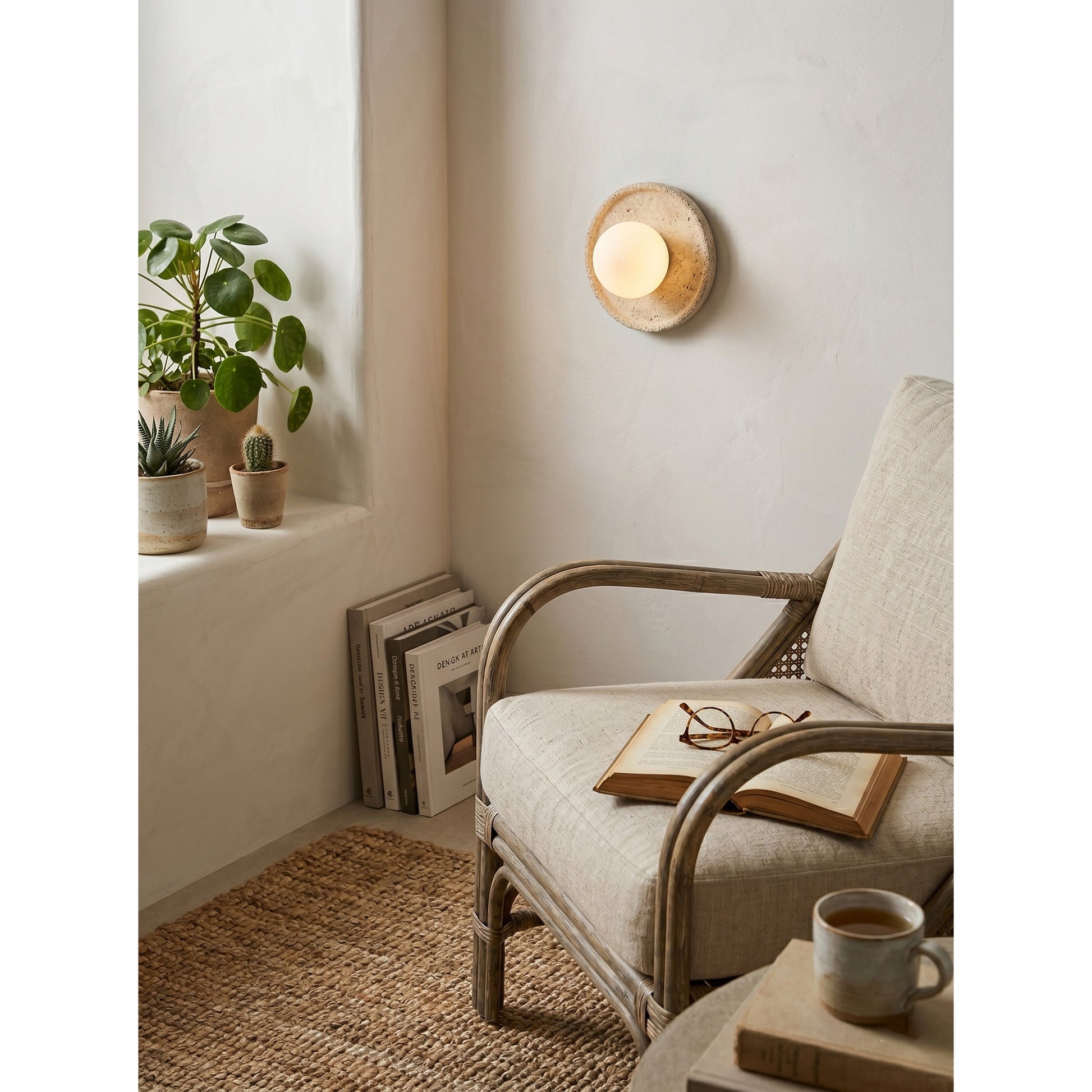 Lifestyle image of the travertine sconce in a modern living room.