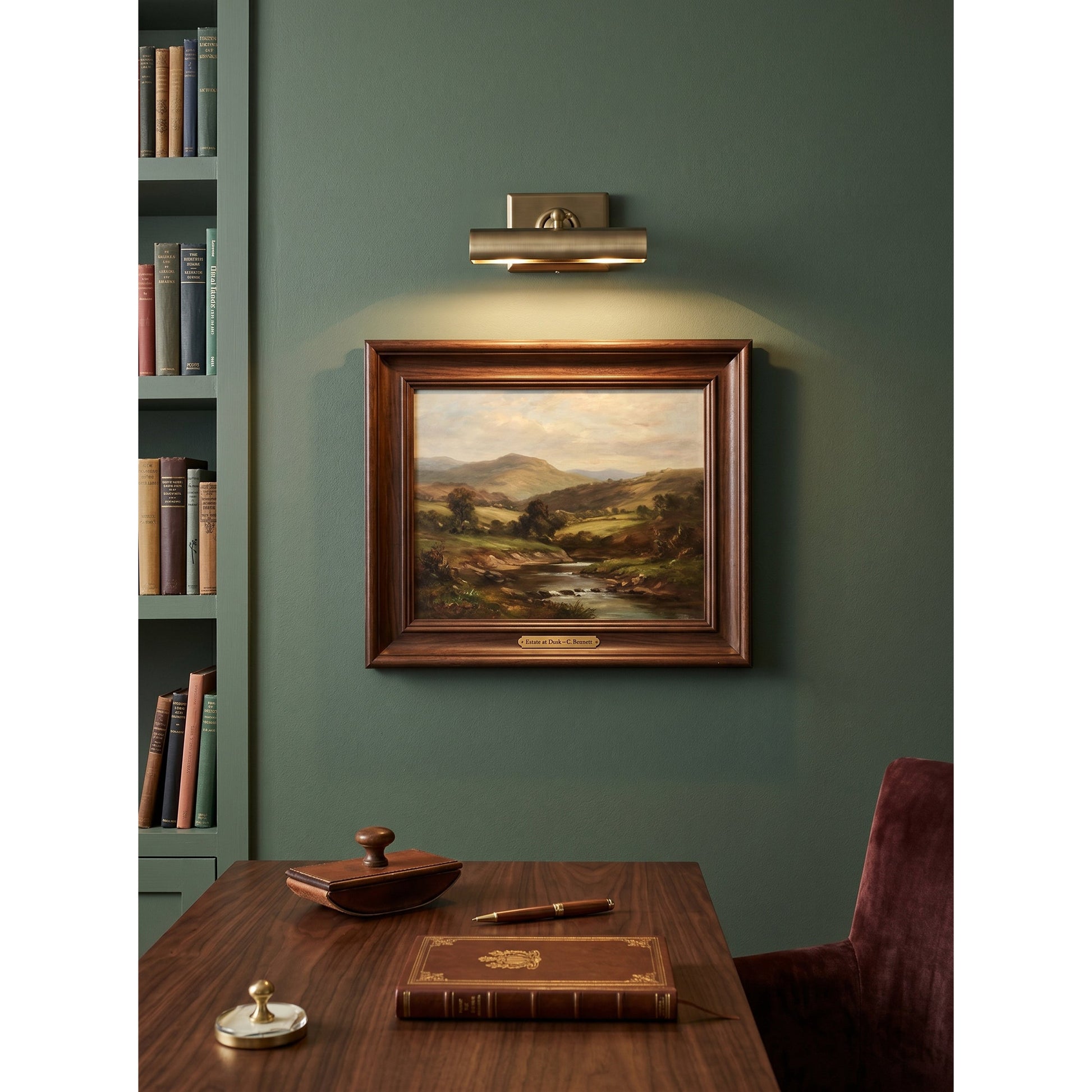 The Steamer Wall Sconce shown in a home office setting over a desk.