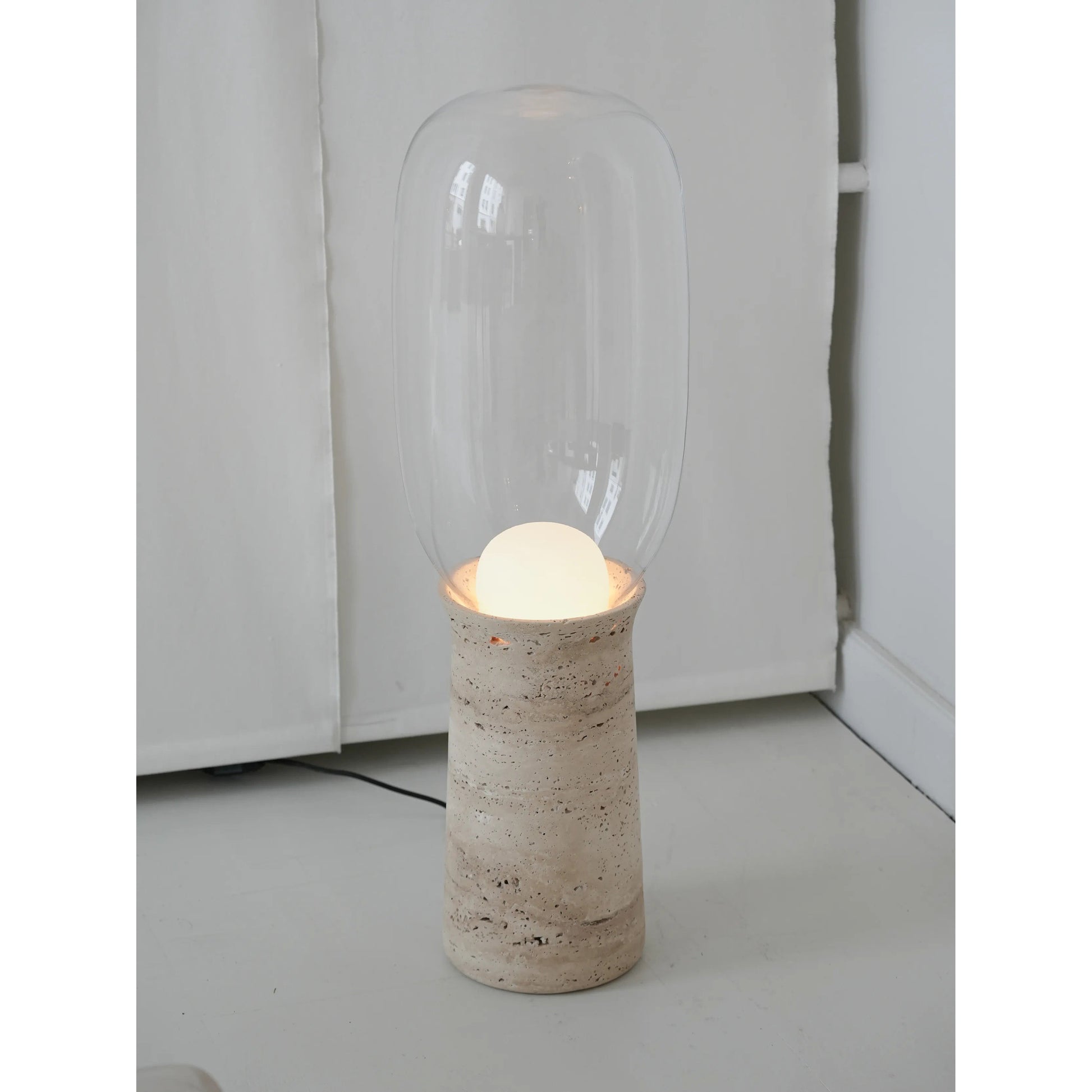 The seamless connection between the stone base and the glass shade.