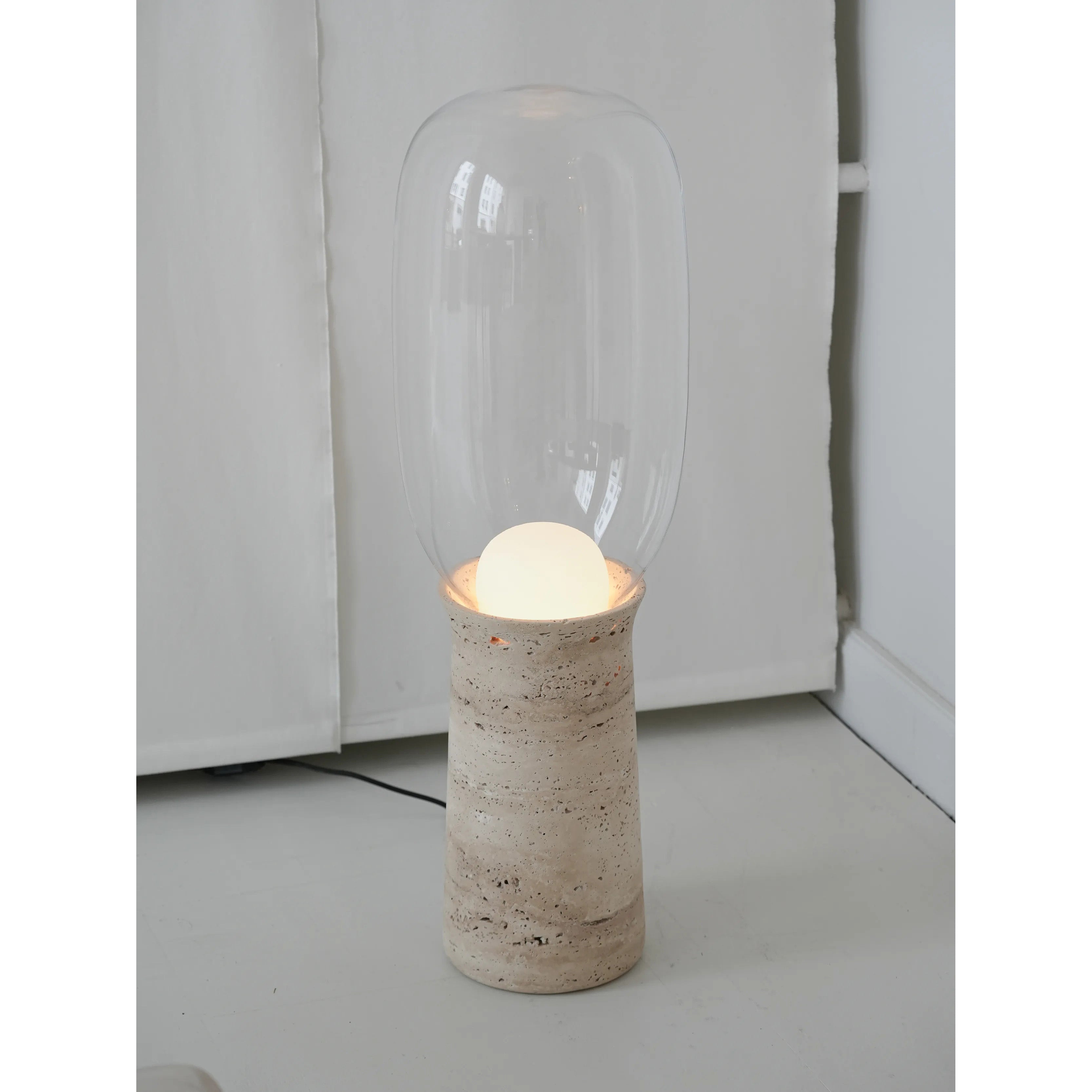 The seamless connection between the stone base and the glass shade.
