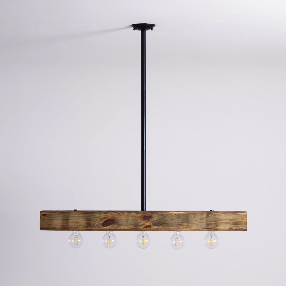 The chandelier shown in a kitchen with dark cabinetry.