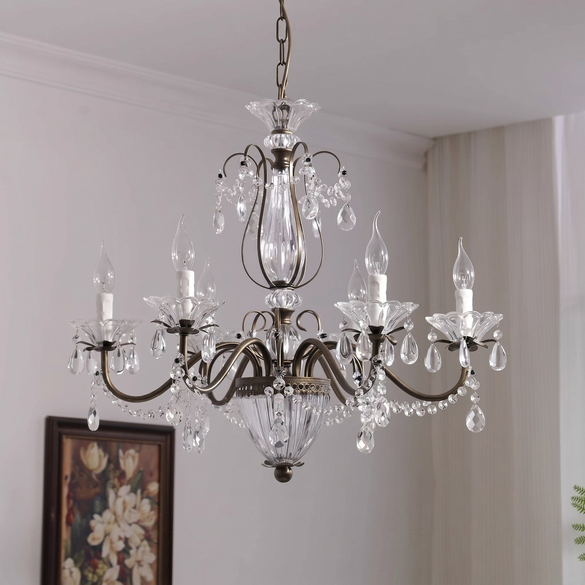 The chandelier illuminated, showing the light refraction through the crystal facets.