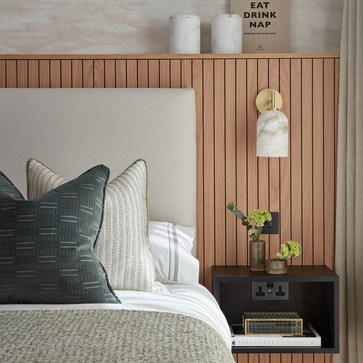 Rae Alabaster Wall Lamp installed in a modern bedroom above a nightstand.