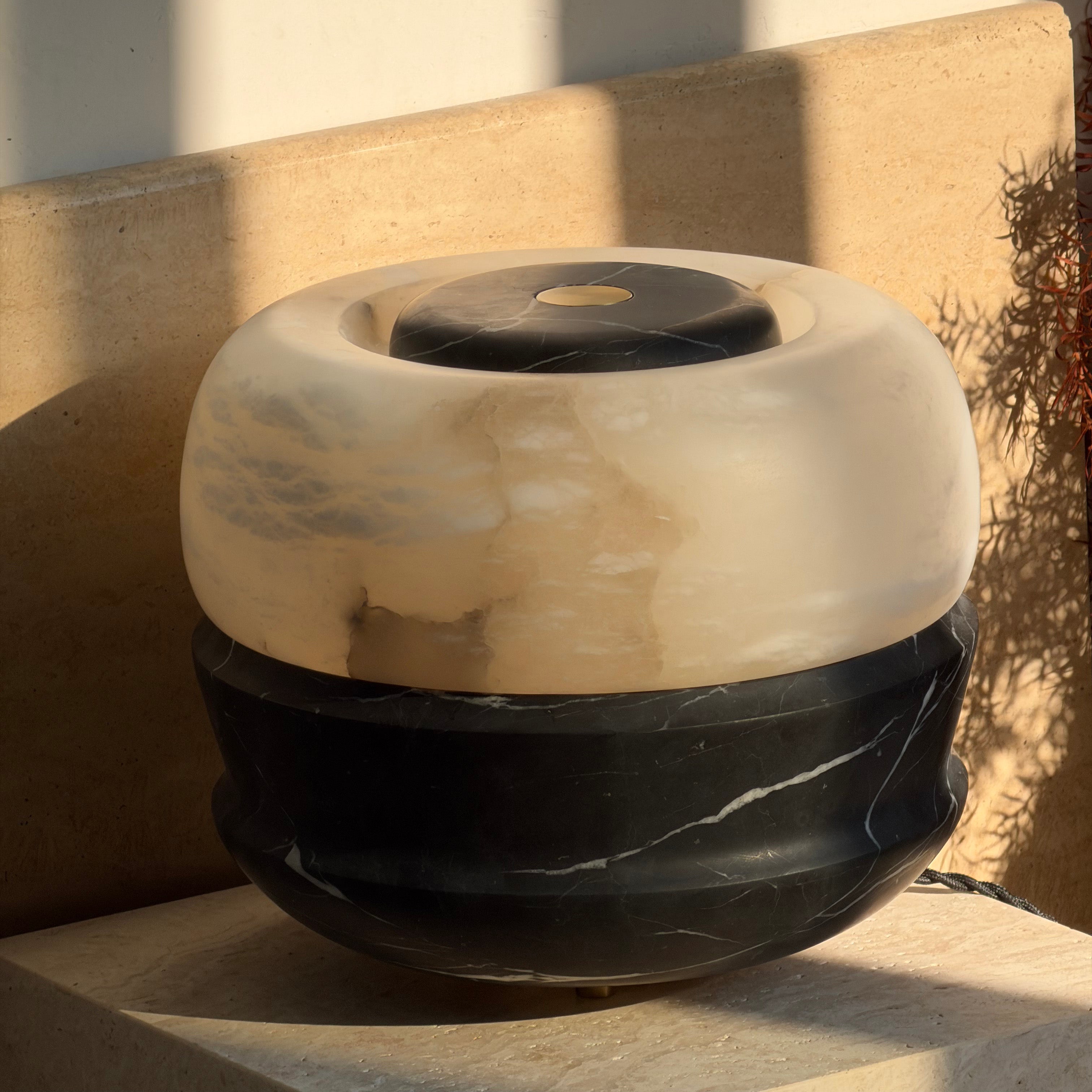 Lifestyle image featuring the white marble Ramson lamp on a nightstand.