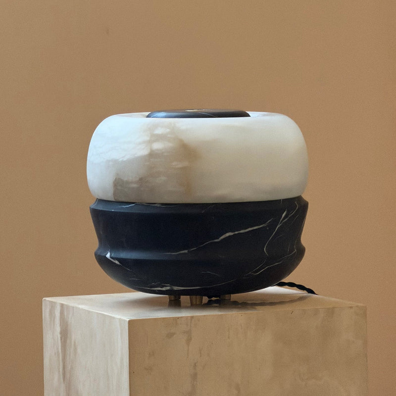 Lifestyle image featuring the amber marble Ramson lamp on an end table.