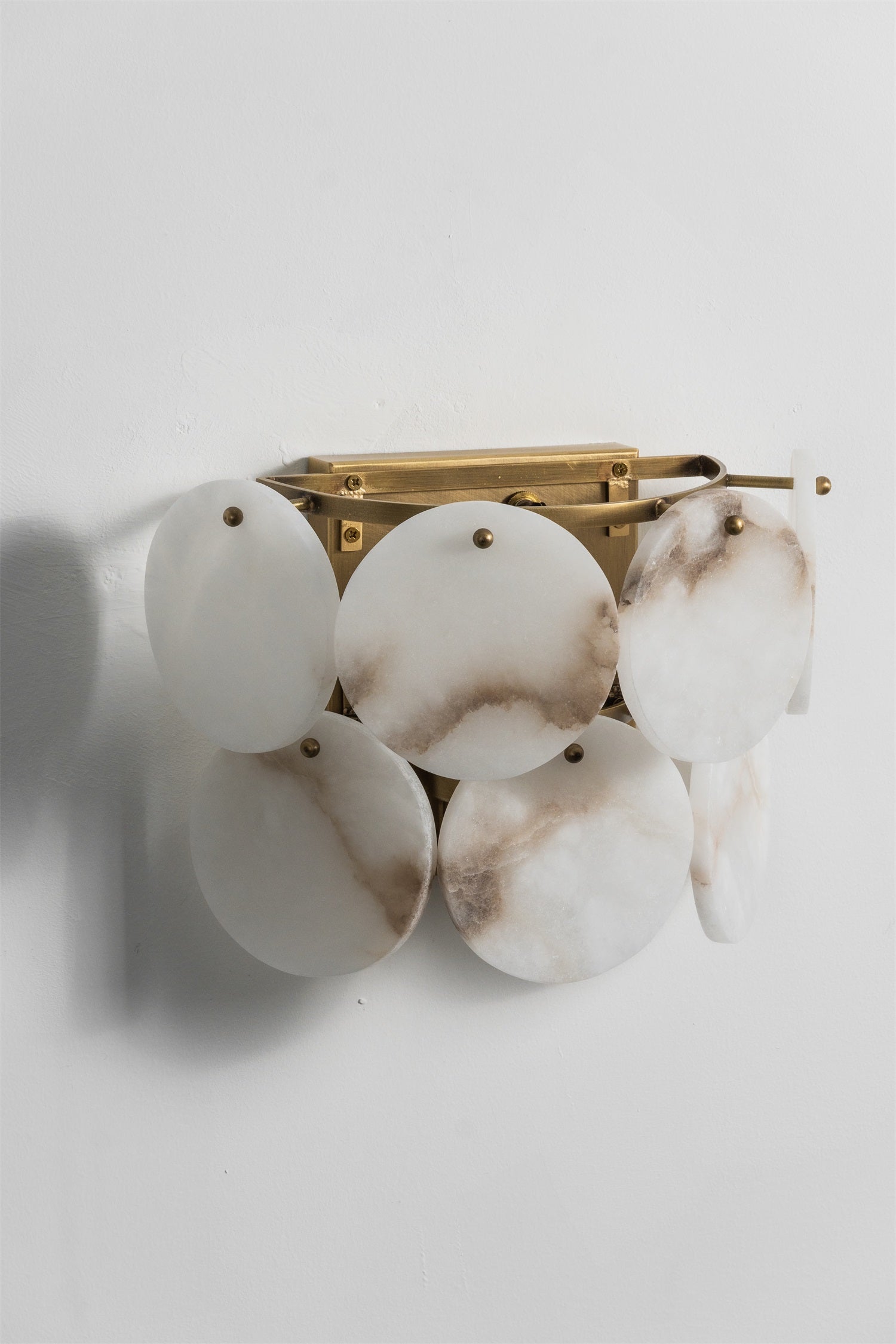 The wall lamp casting ambient light in a bedroom.