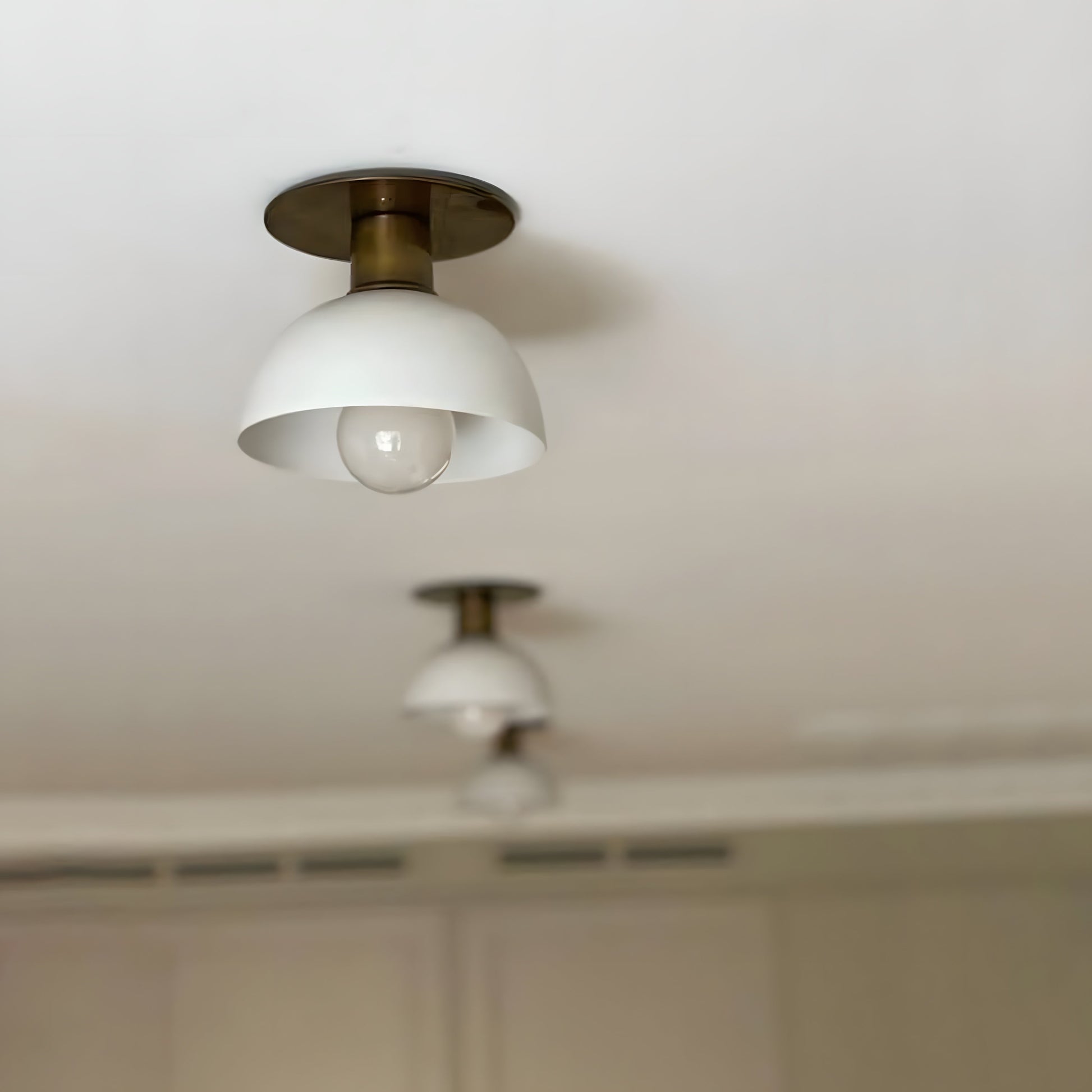 Close-up of the Rodanthe Ceiling Lamp's aluminum dome shade and large LED globe bulb.