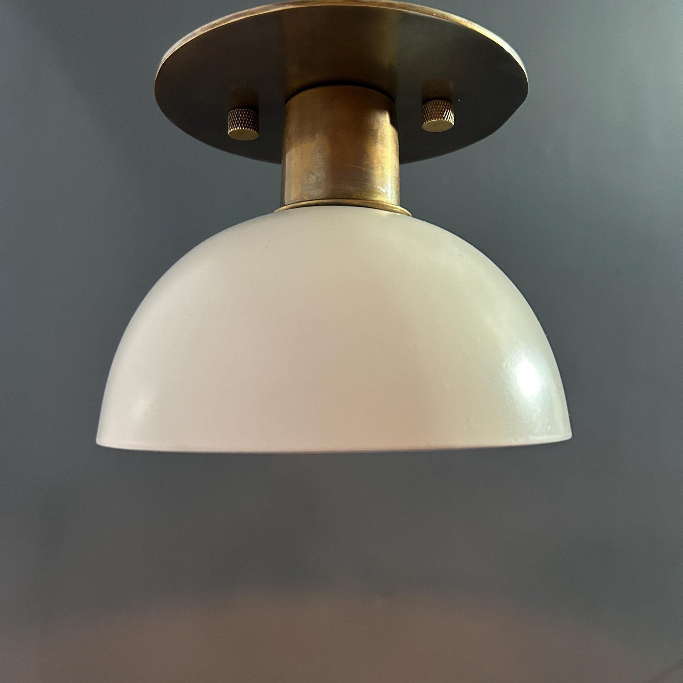 Close-up of the antique brass finish on the lamp's canopy.
