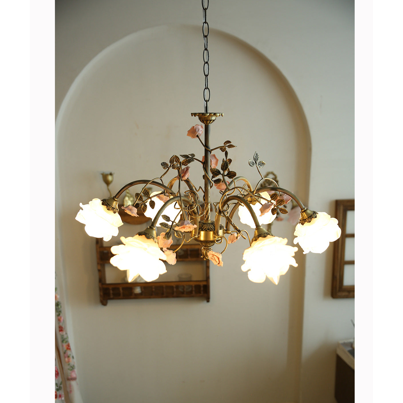 Detail of the ceramic flower decorations and brass leaves entwined on the frame.