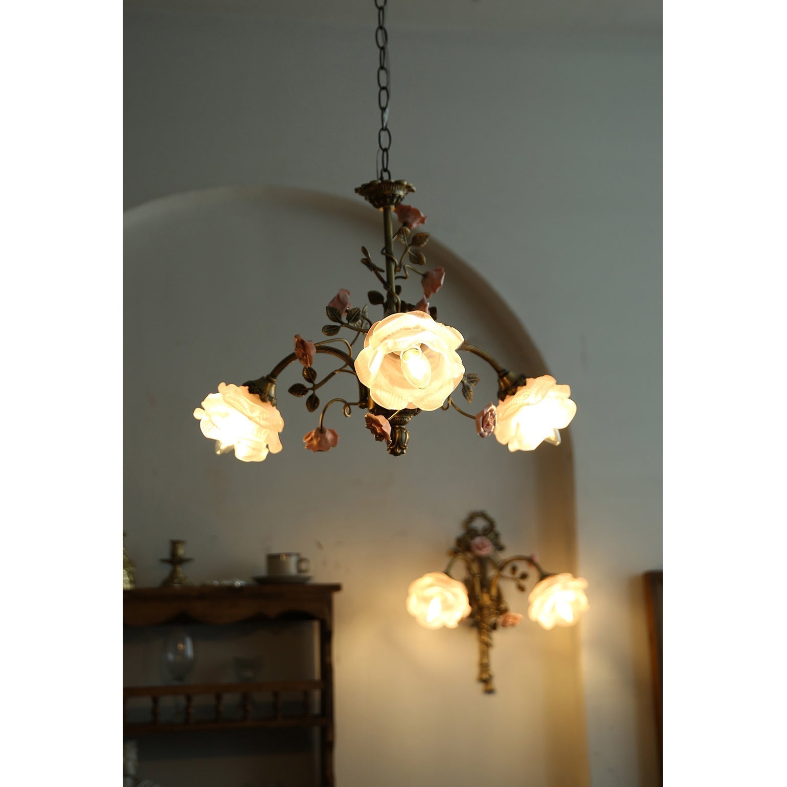 Unlit view of the chandelier, showcasing the pink and brass colors.