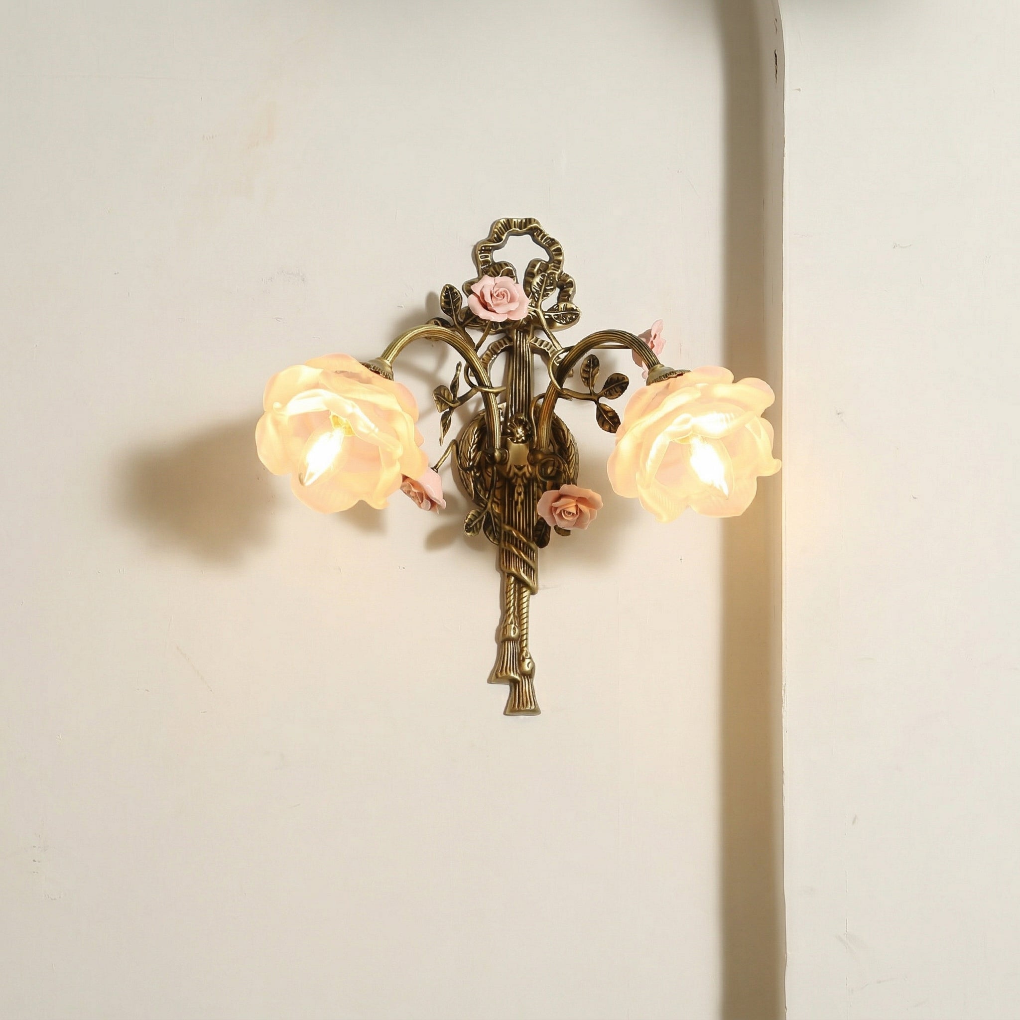 Rosalie sconce shown illuminated, casting a warm, inviting glow.