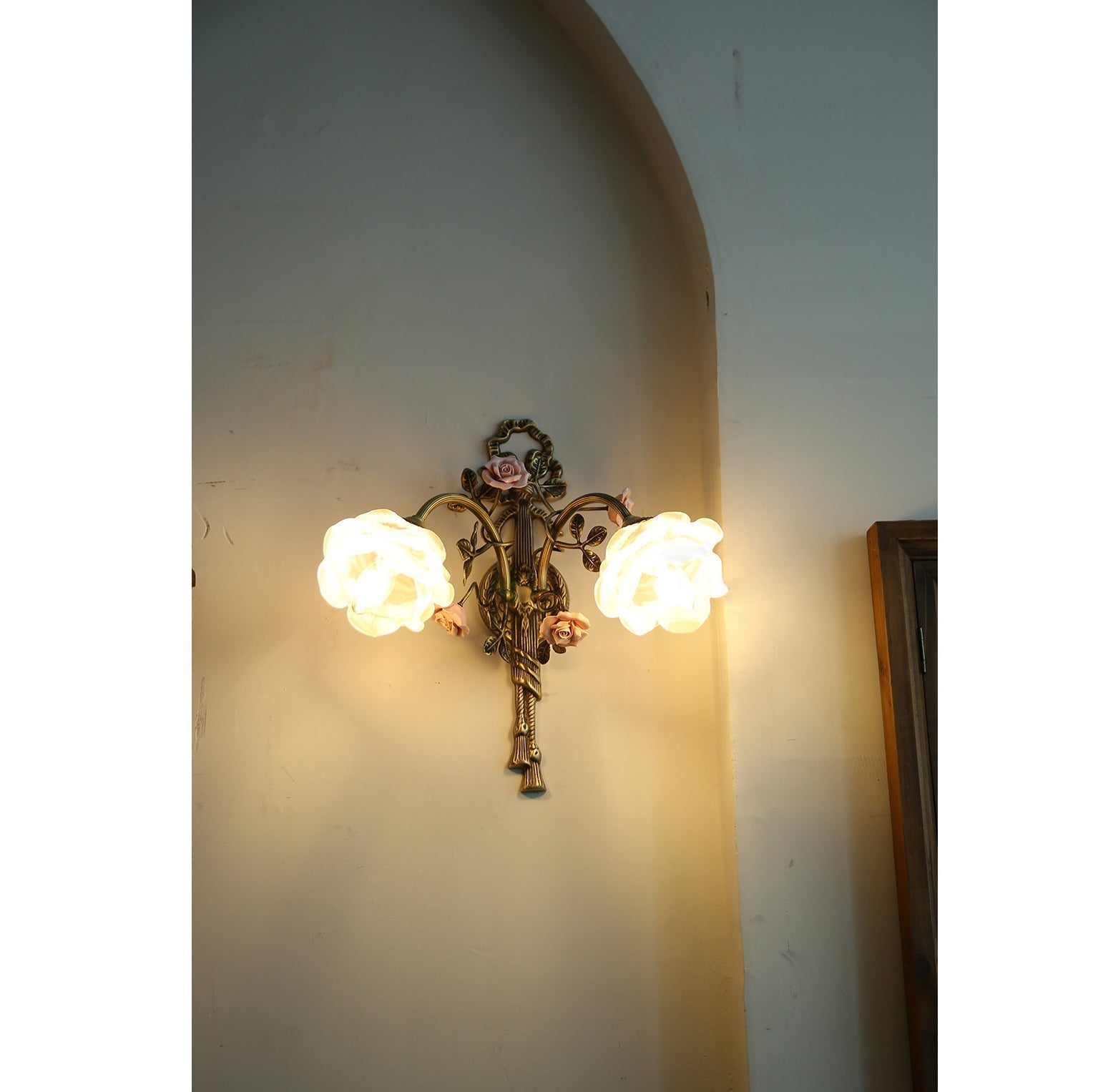 Lifestyle image of the Rosalie sconce in a bedroom setting.