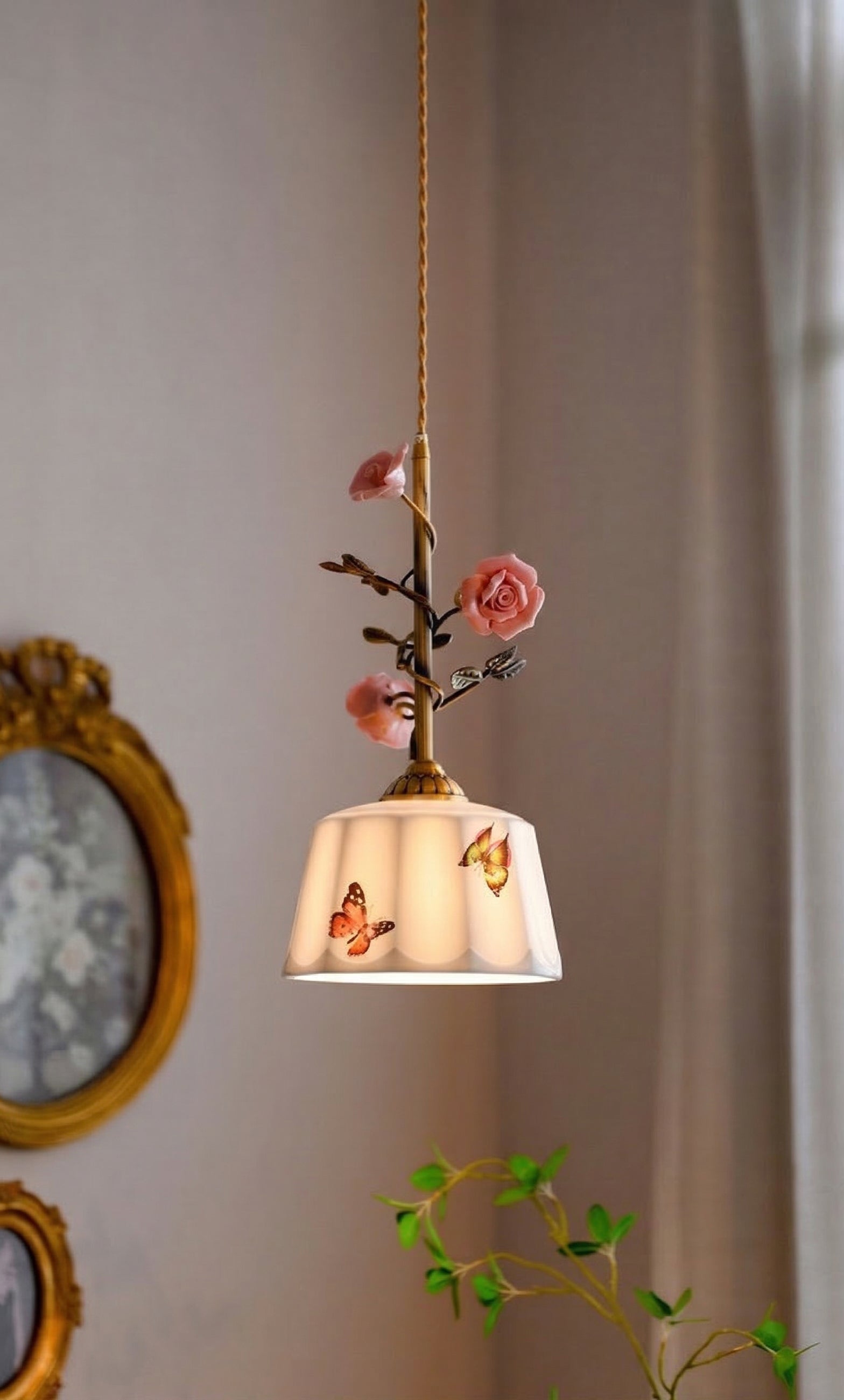 Close-up view of the delicate pink ceramic roses and amber butterfly details on the pendant lamp.