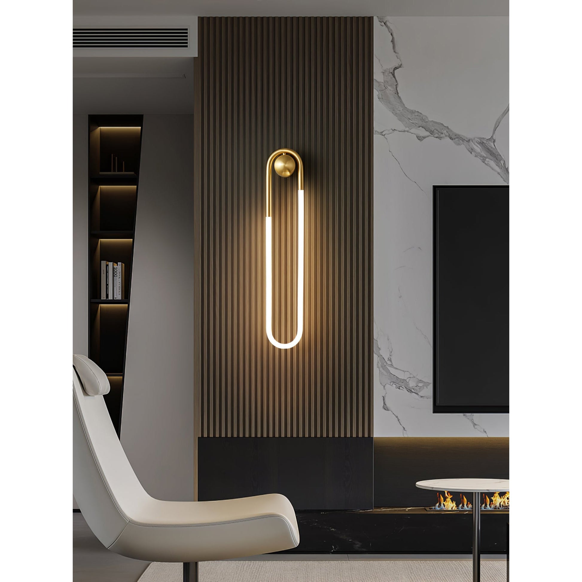 Rudi Loop Wall Lamp in brass finish in a living room context.