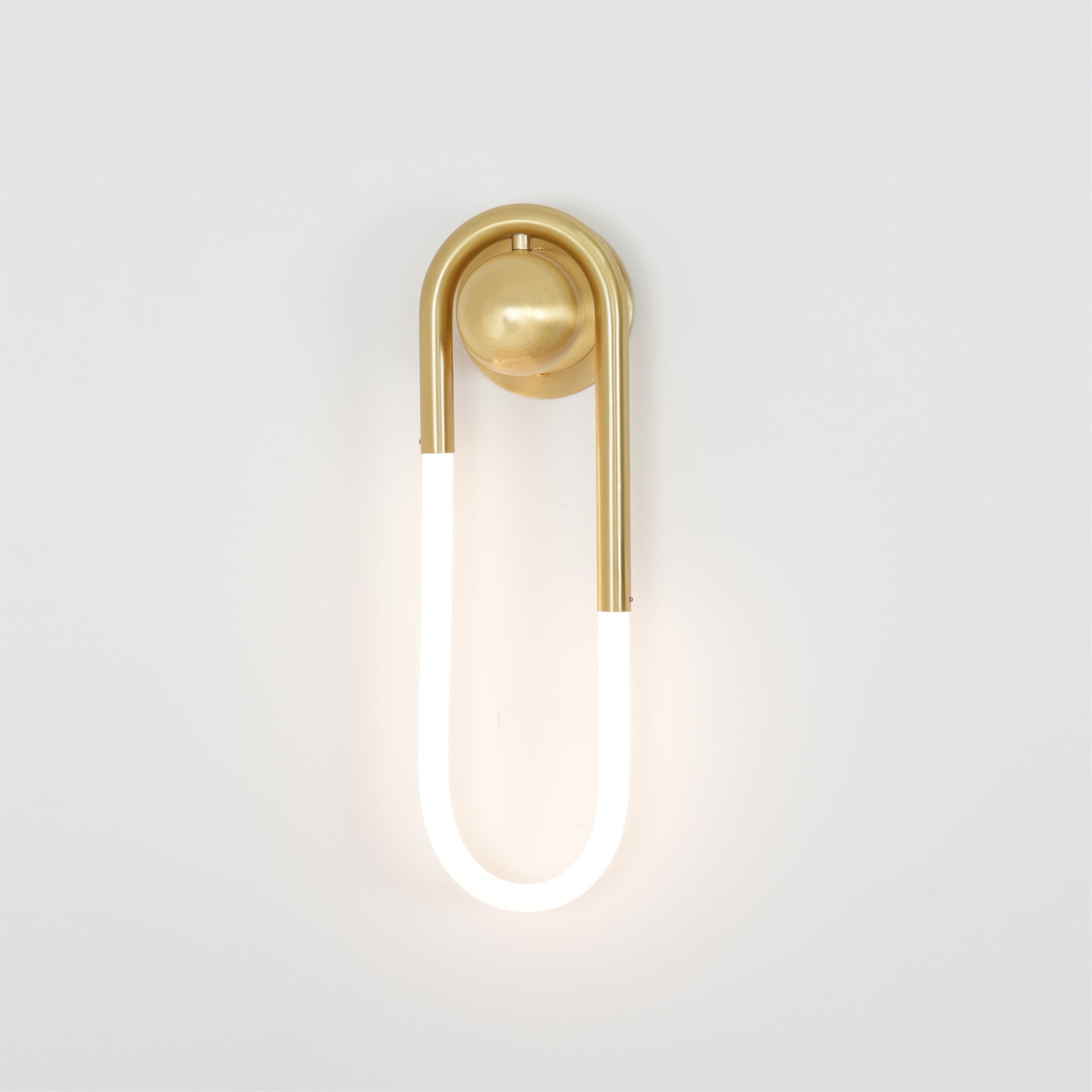 Angled view of the brass lamp, highlighting its fluid shape.