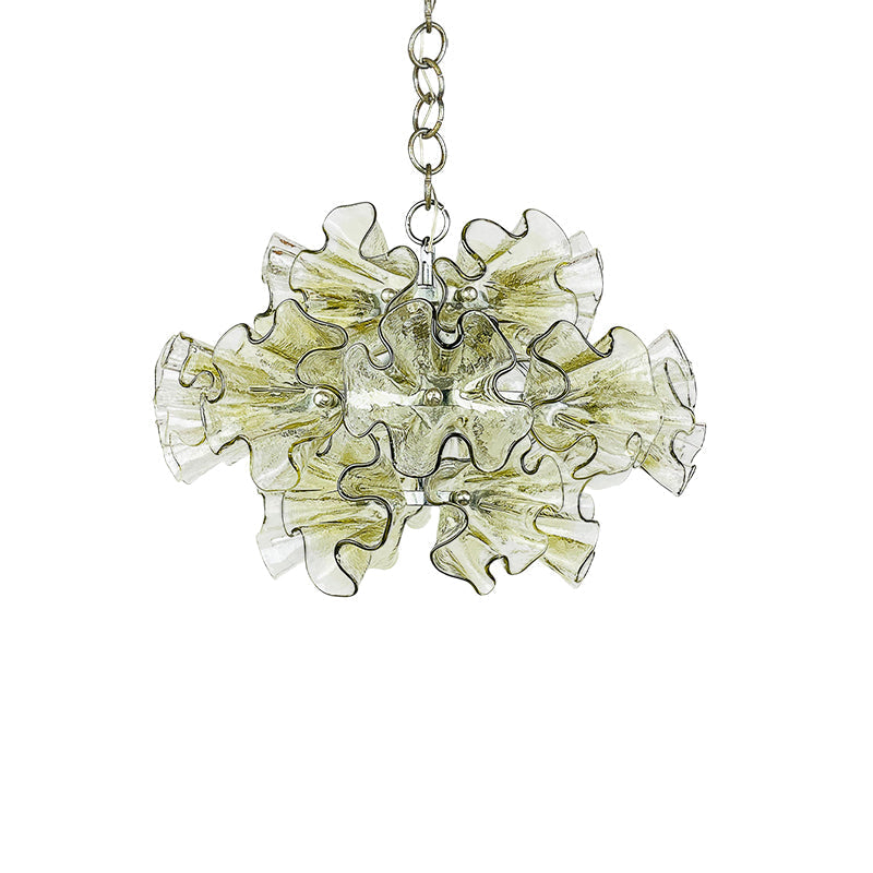 The unlit chandelier against a dark, textured wall.