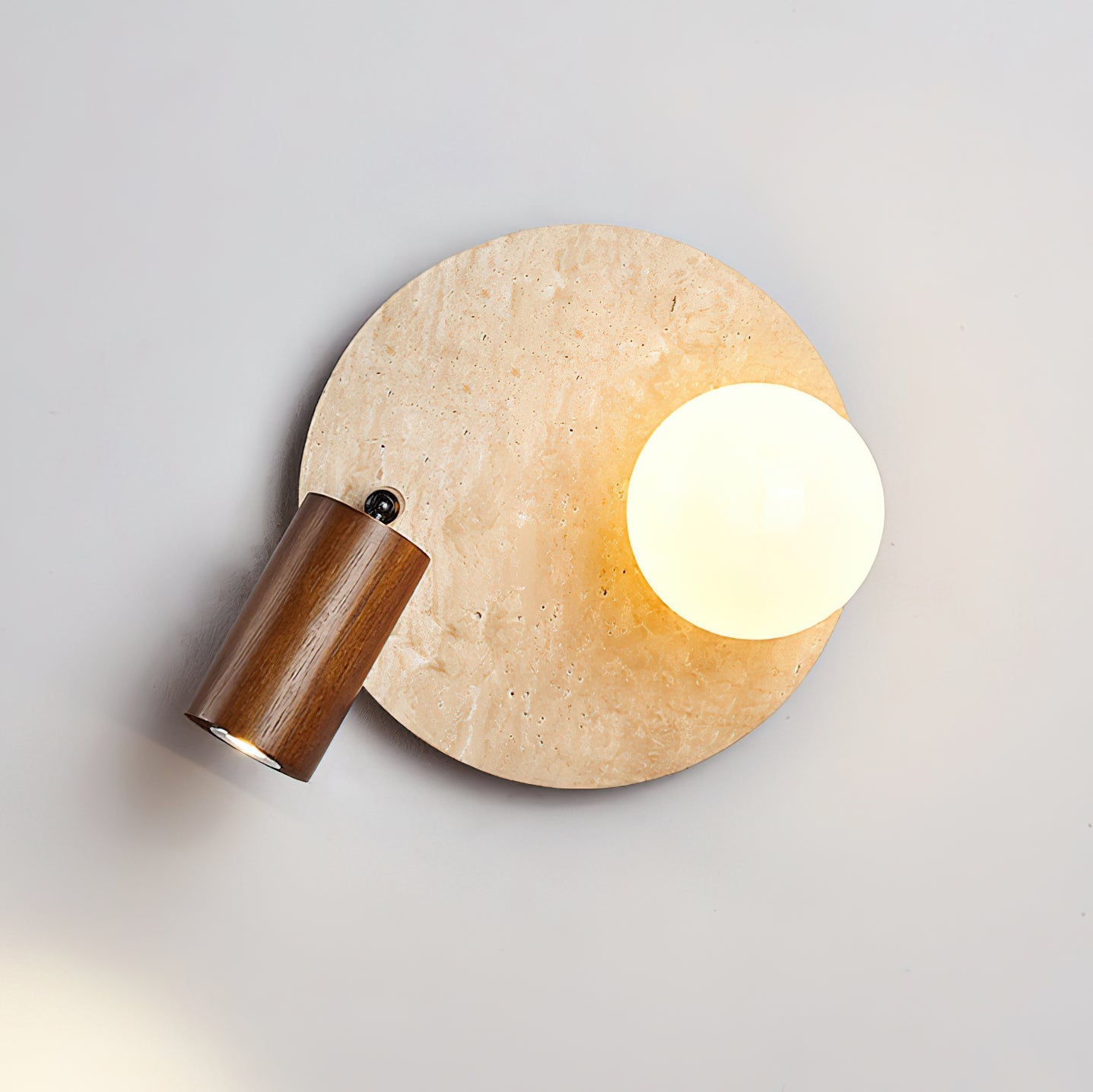 Close-up on the junction between the travertine stone and the light fixture.