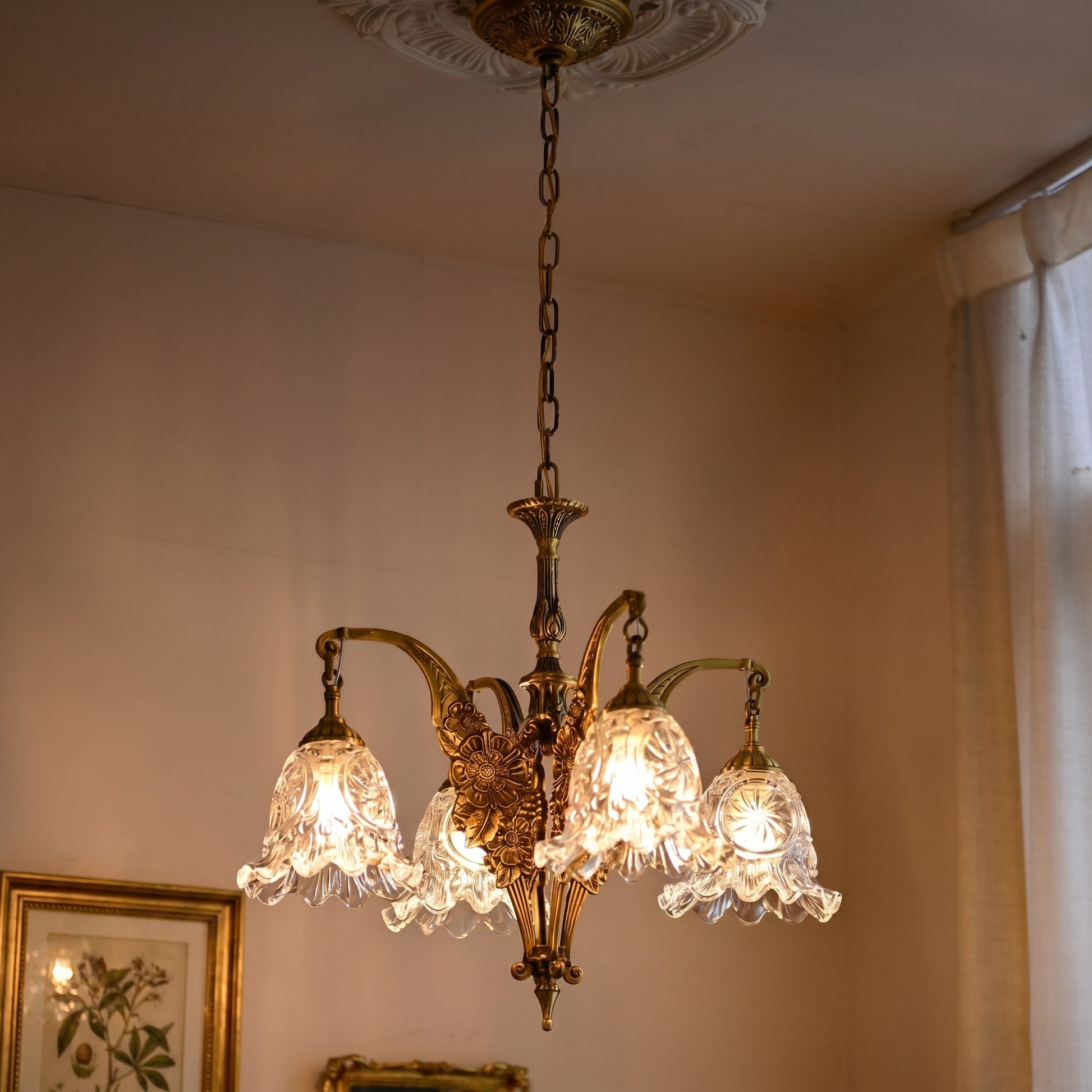 Close-up of the intricate botanical motifs on the brass arms of the Savannah Chandelier.