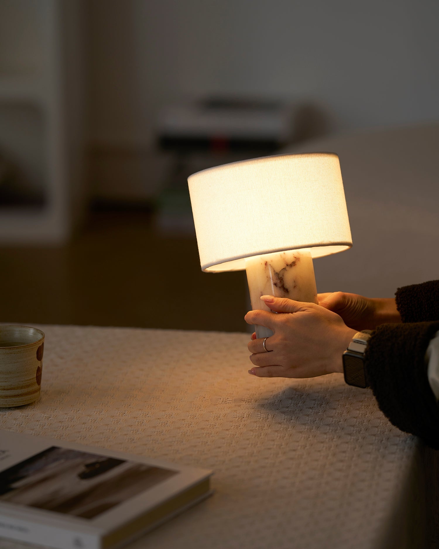 The lamp casting a warm glow on a nearby wall.