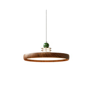 Sia Scalloped Saucer Pendant Light in walnut finish hanging in a dining room.