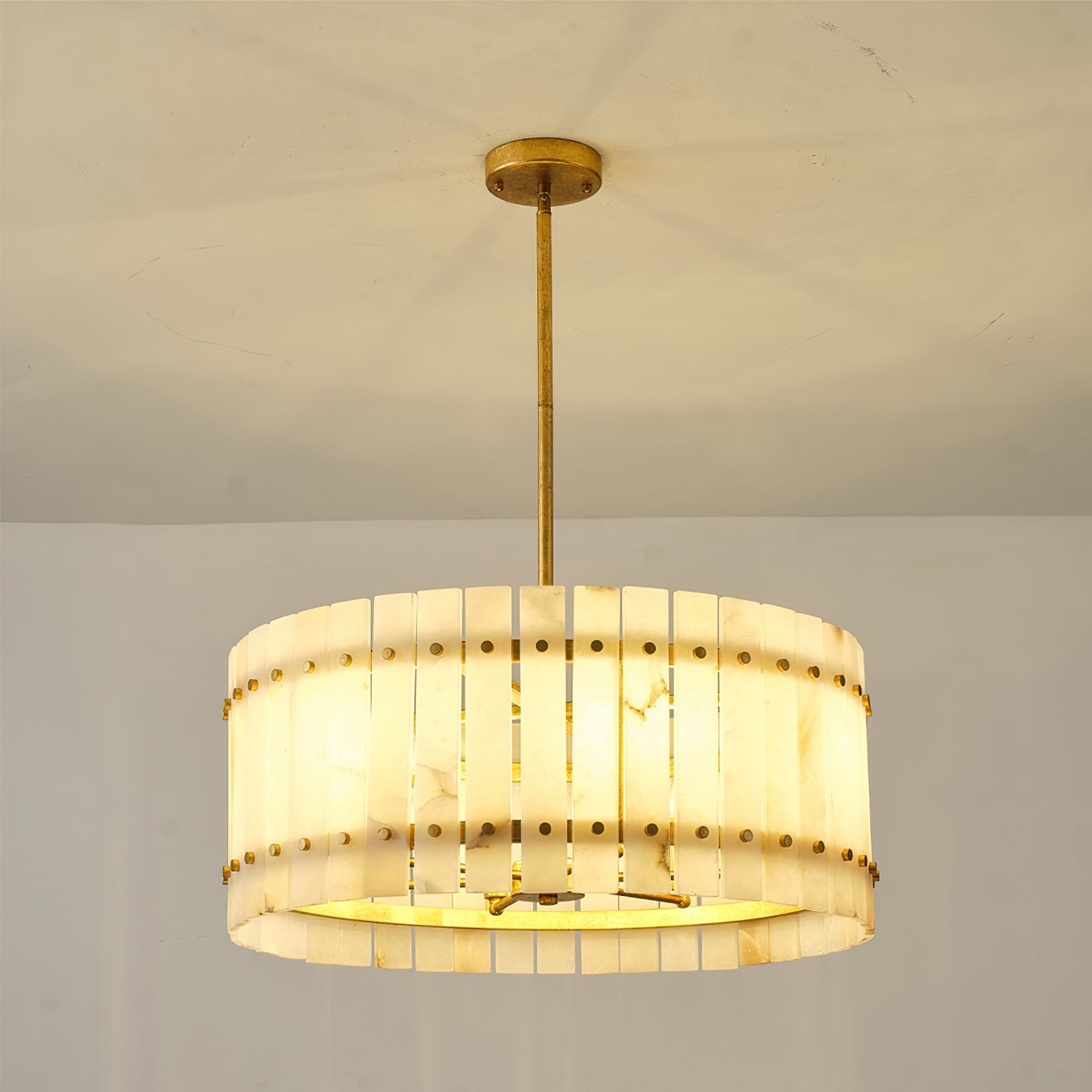 The chandelier installed in a high-ceiling entryway.
