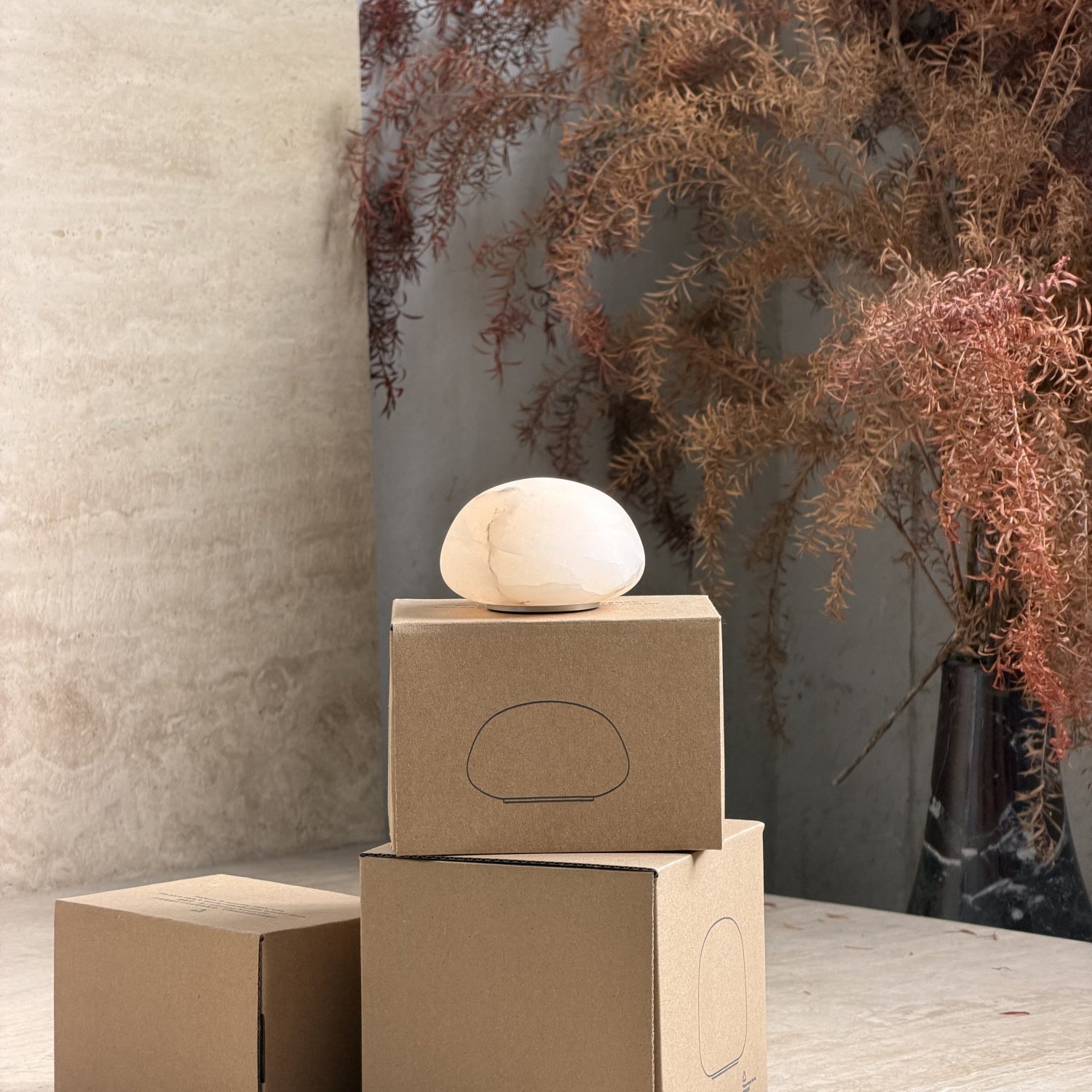 Front view of the Alabaster Petite Portable Lamp with warm amber light.