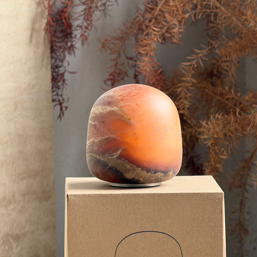 The alabaster lamp glowing brightly in a dimly lit room.