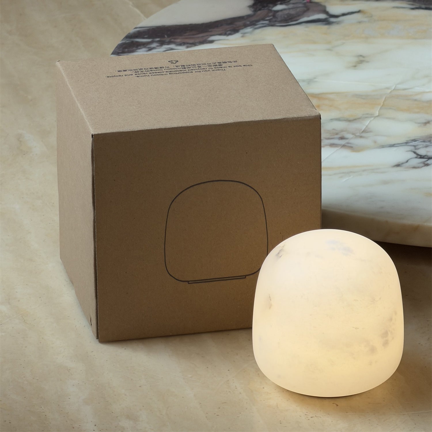 The small alabaster lamp illuminating a decorative corner shelf.