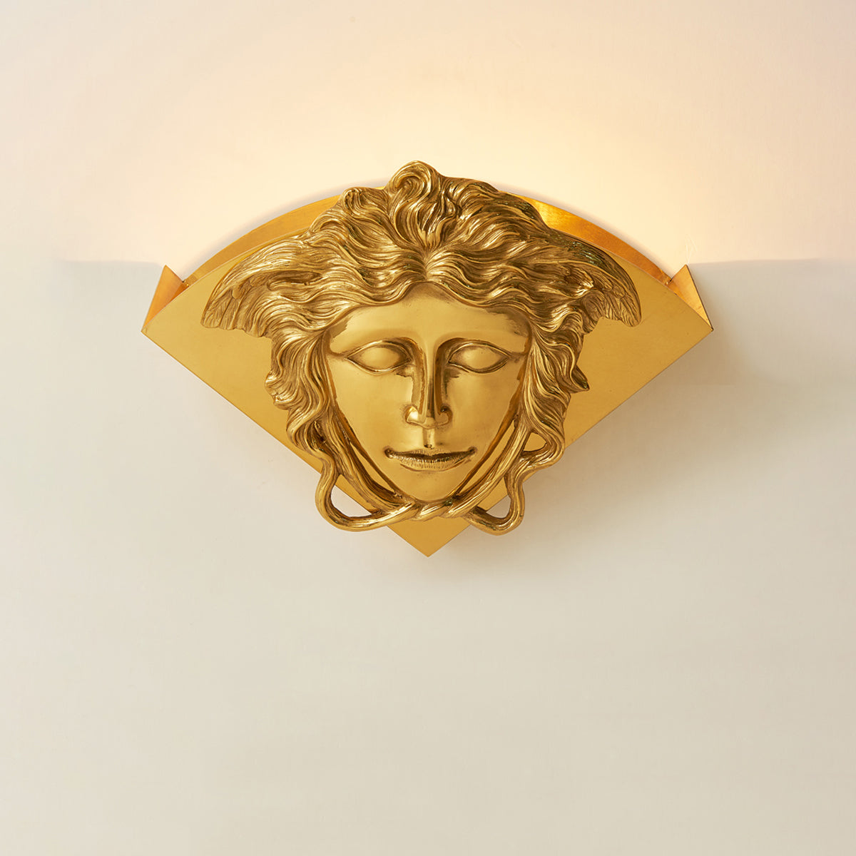Sphinx Brass Wall Lamp paired with other home decor items.