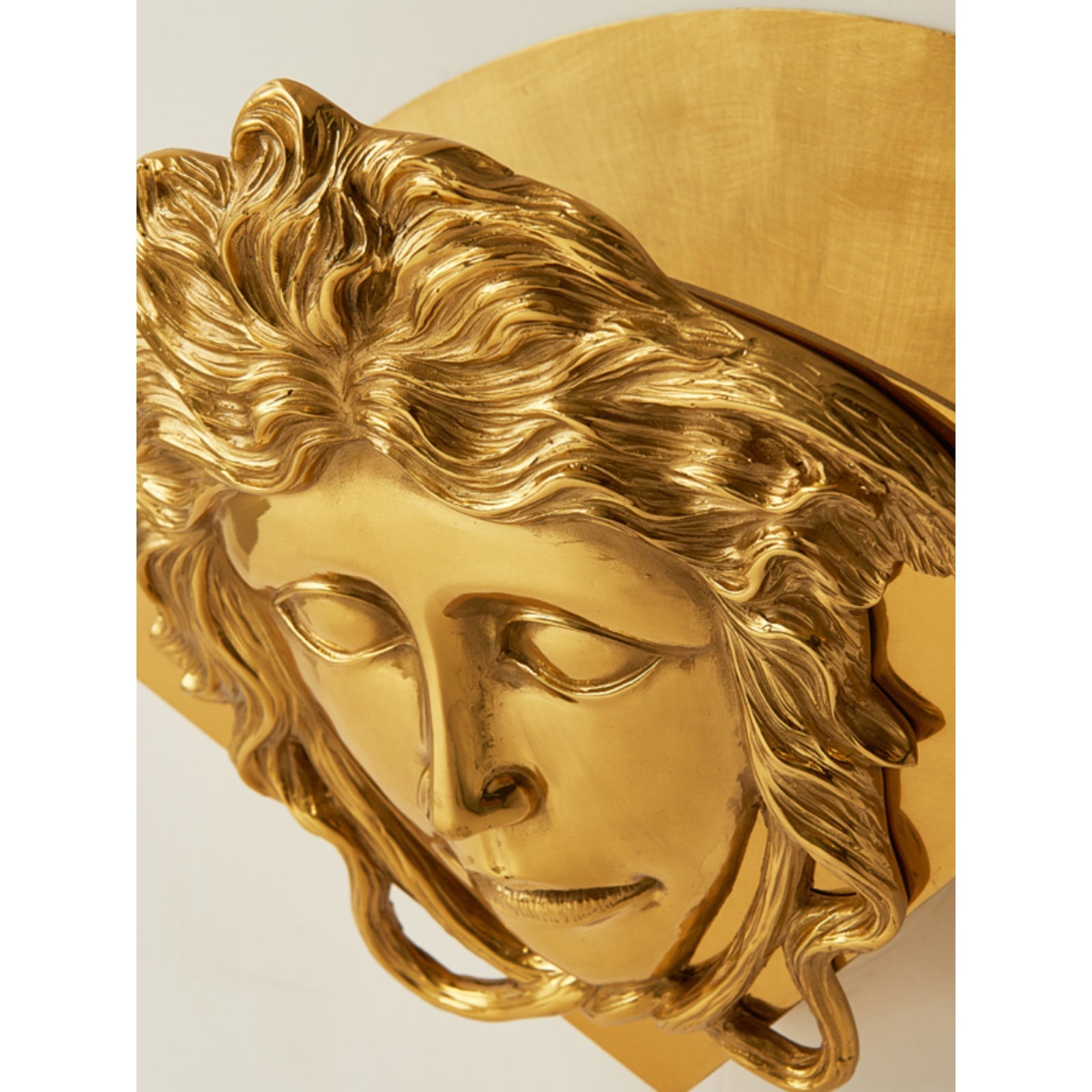 The Sphinx Brass Wall Lamp against a dark colored wall for contrast.