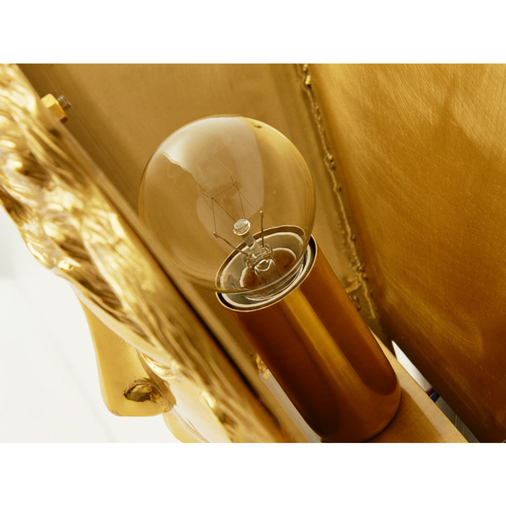 The warm light from the Sphinx Brass Wall Lamp creating a cozy atmosphere.