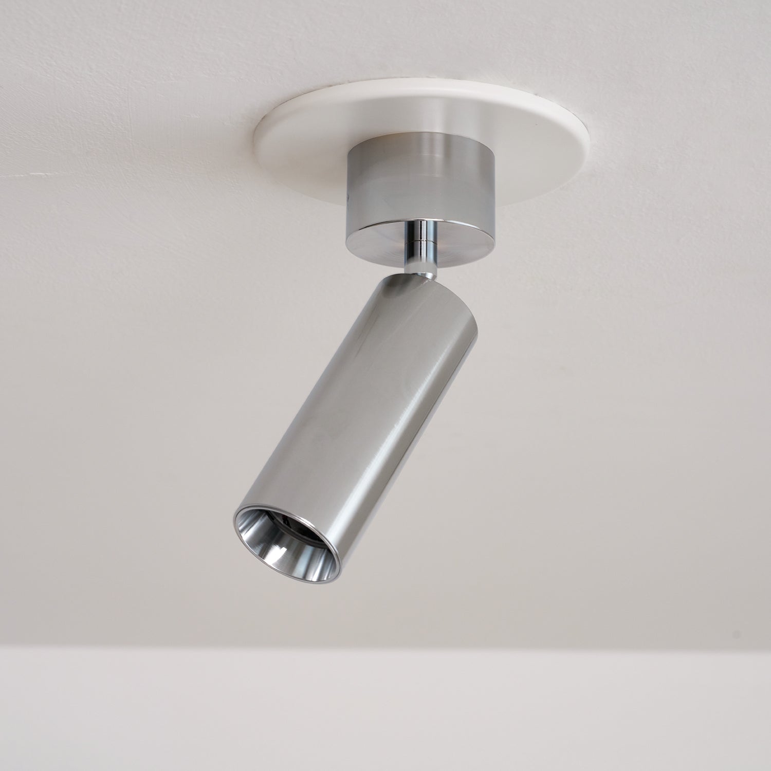 Stanly spotlight in nickel finish, mounted on a wooden beam.