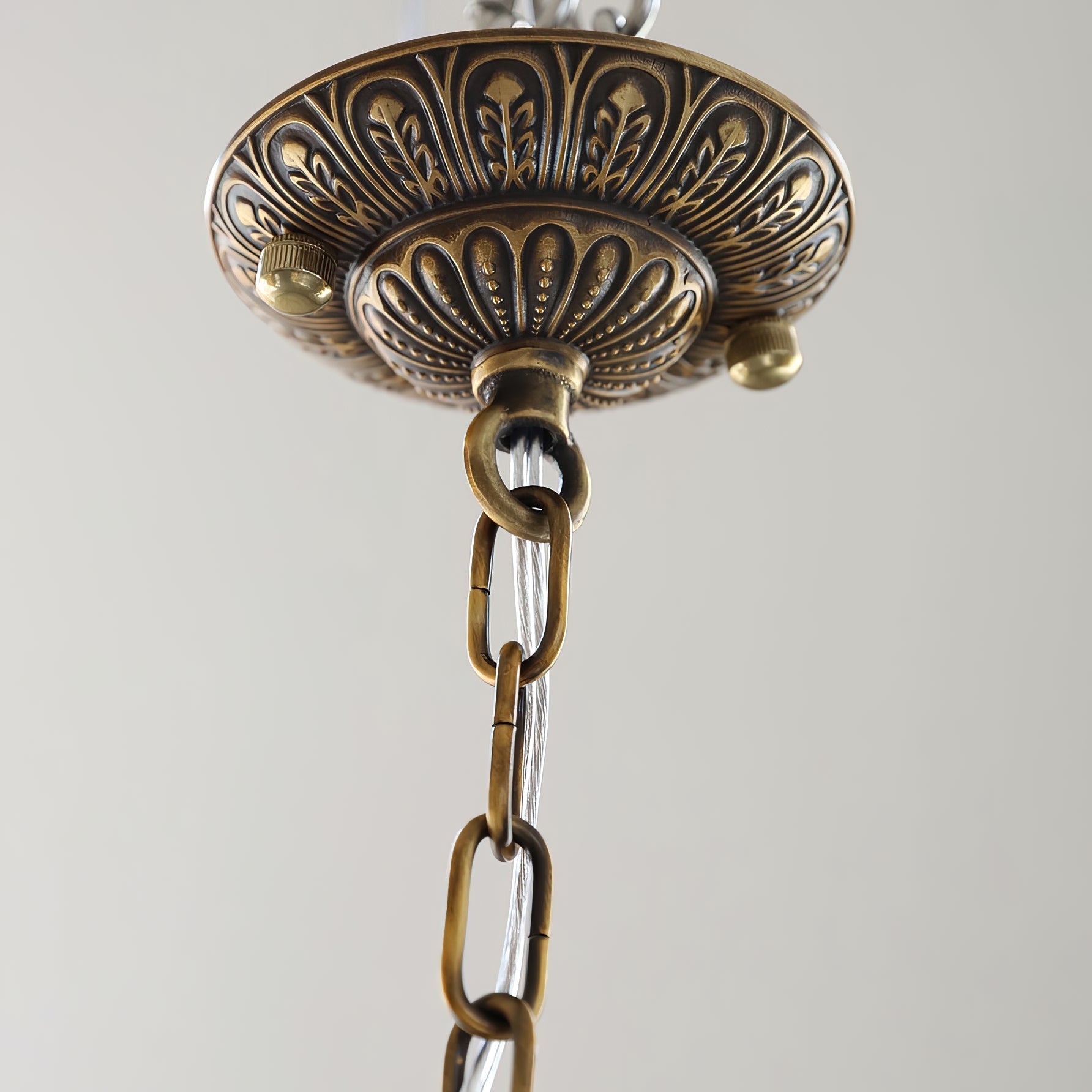 The chandelier with light reflecting off its crystal and copper elements.