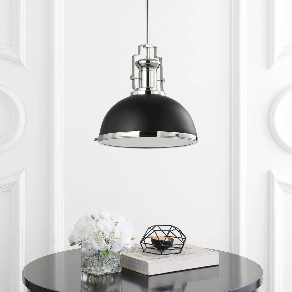 A pair of Staub Pendant Lamps hanging over a modern kitchen island.