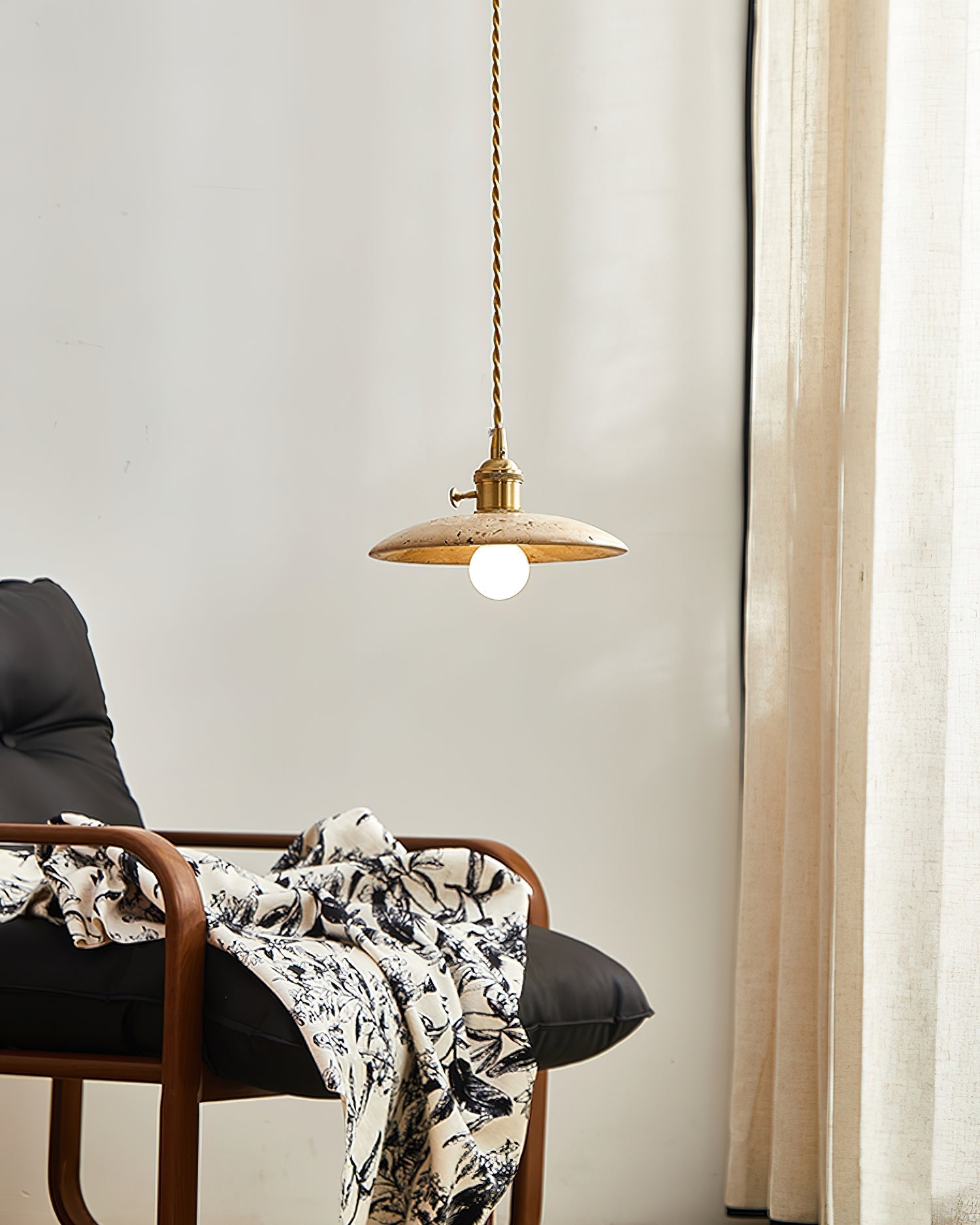Detail shot of the warm brass hardware connecting the shade and cord.