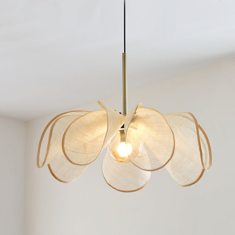 The black pendant lamp illuminated, showing the light filtering through the petals.