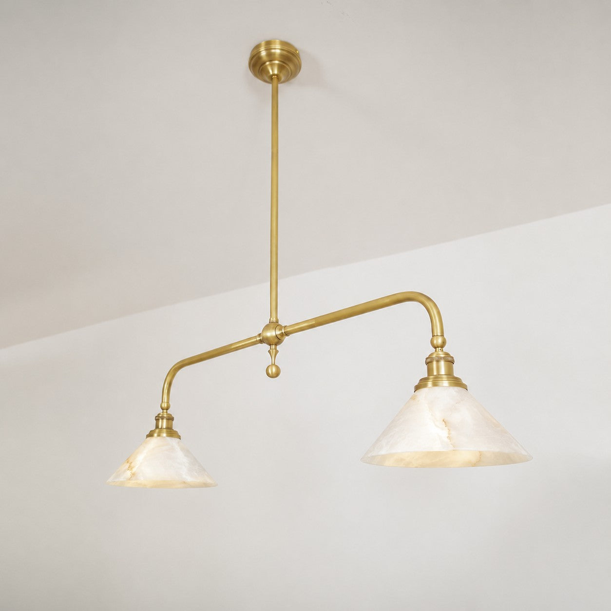 The pendant light providing ambient lighting over a wooden dining table.