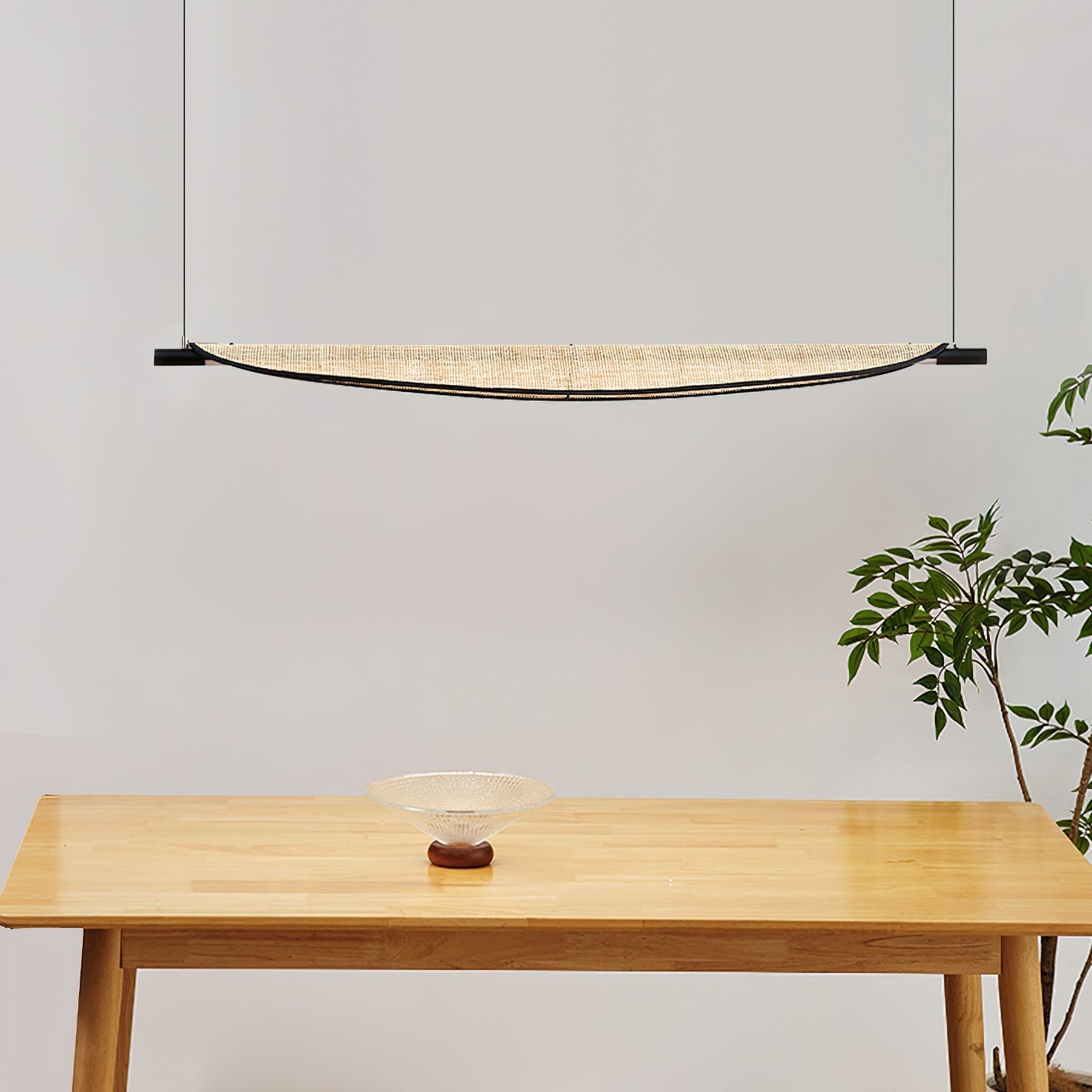 Close-up view of the handwoven rattan shade on the Thula chandelier.