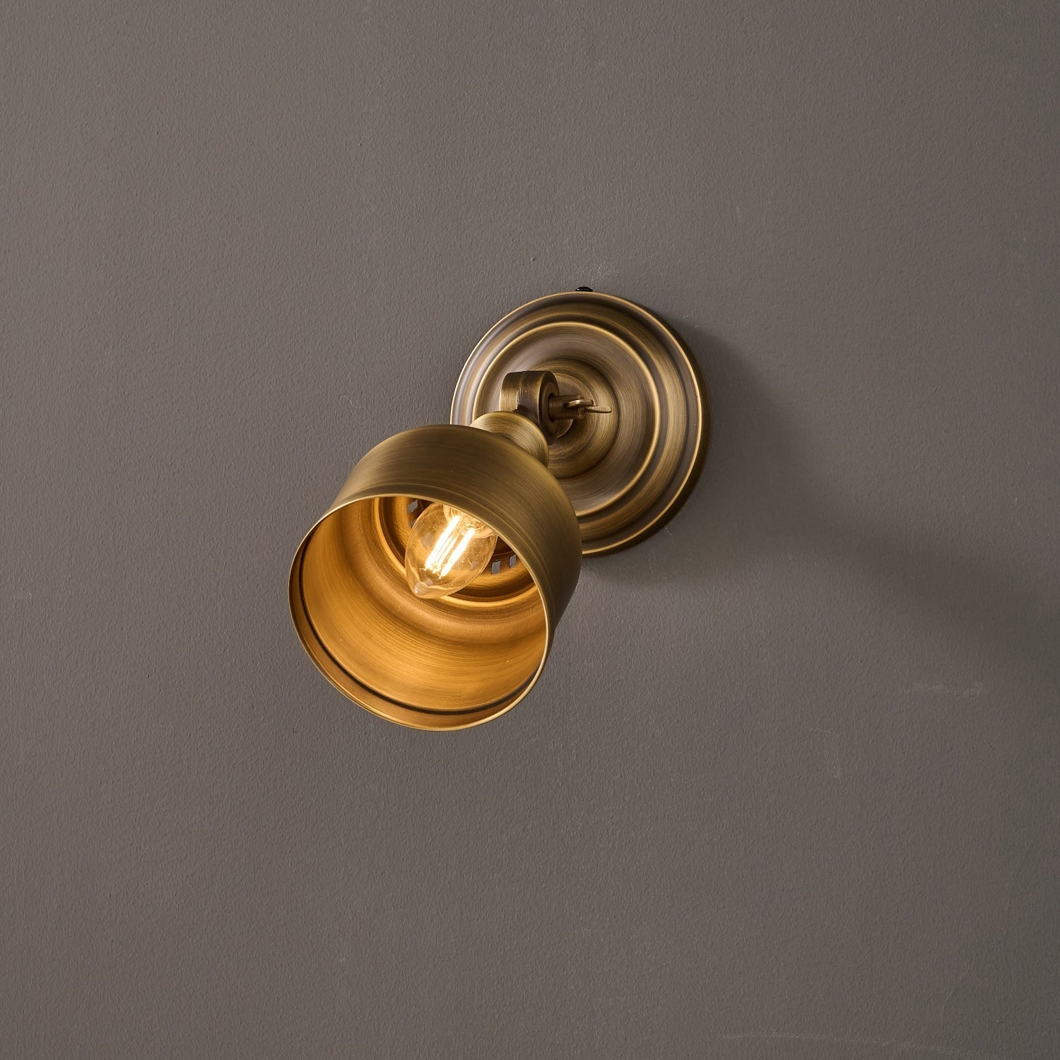 The warm light from the lamp illuminating a textured wall.