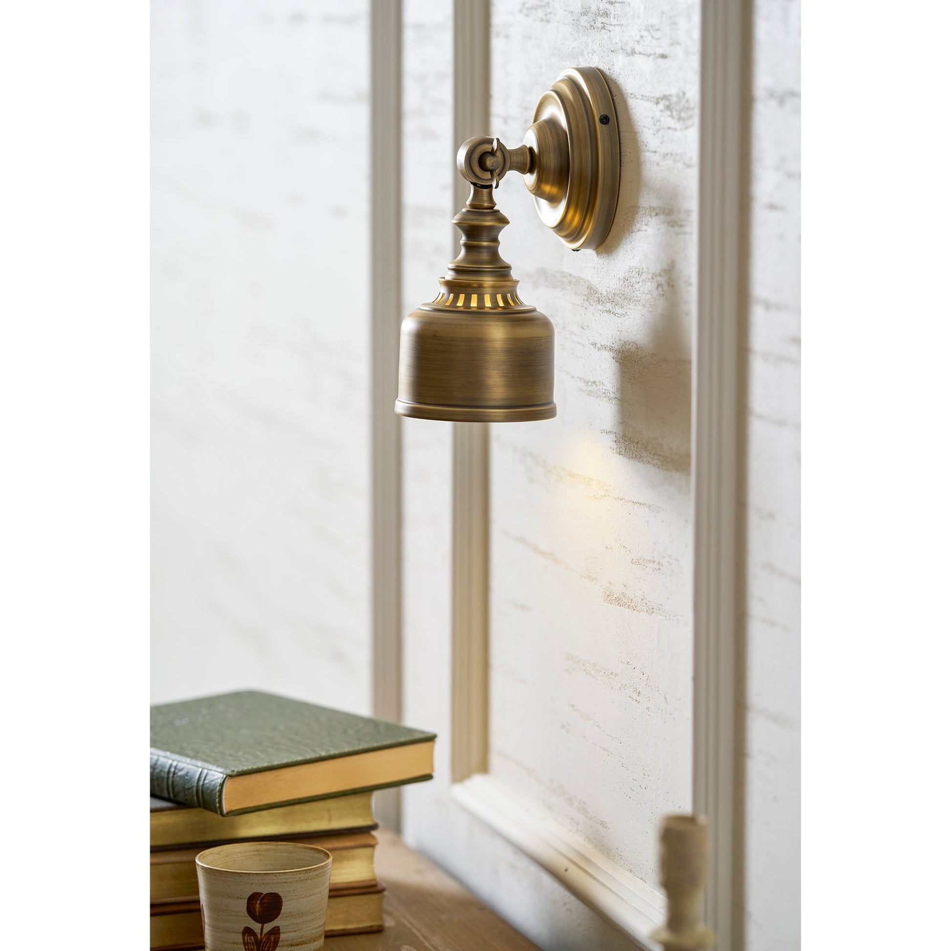 The lamp in a library or study setting above a bookshelf.