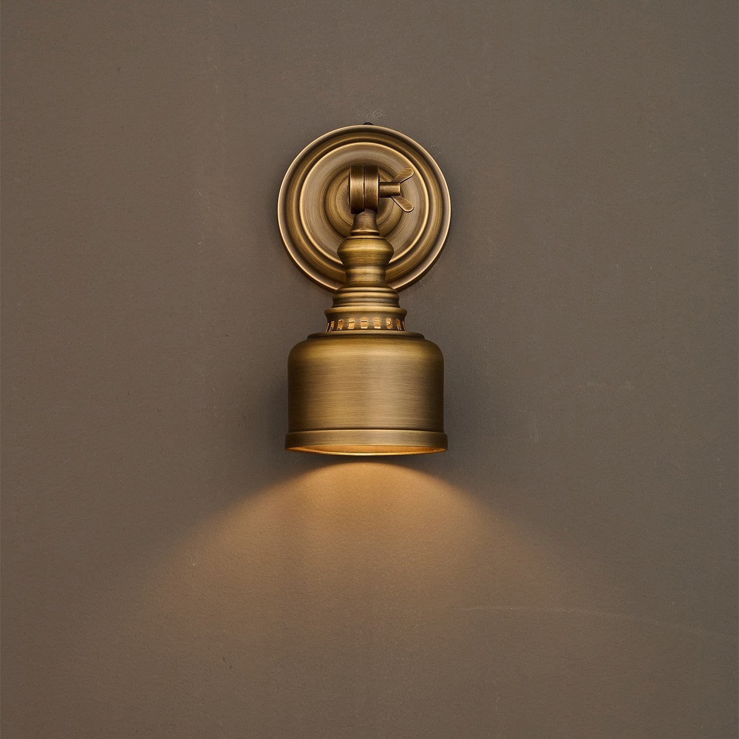 The Timarron Wall Lamp against a dark painted wall.