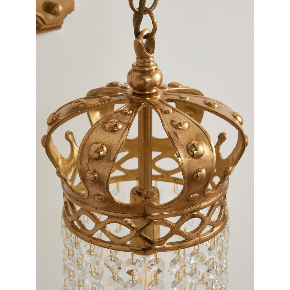 Full product view of the Timon Brass Crown Wall Lamp from a distance.