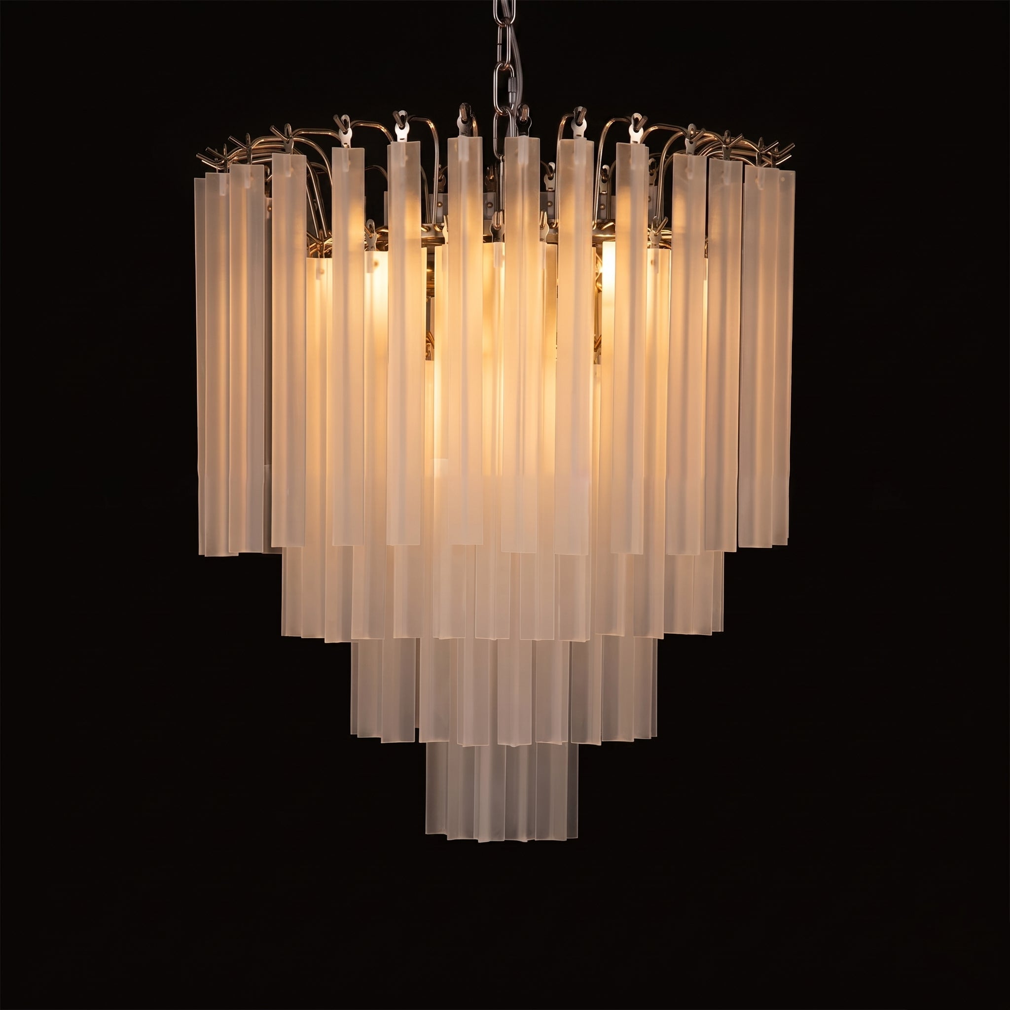 The 60cm Triedra Cascade Chandelier hanging over a dining table.